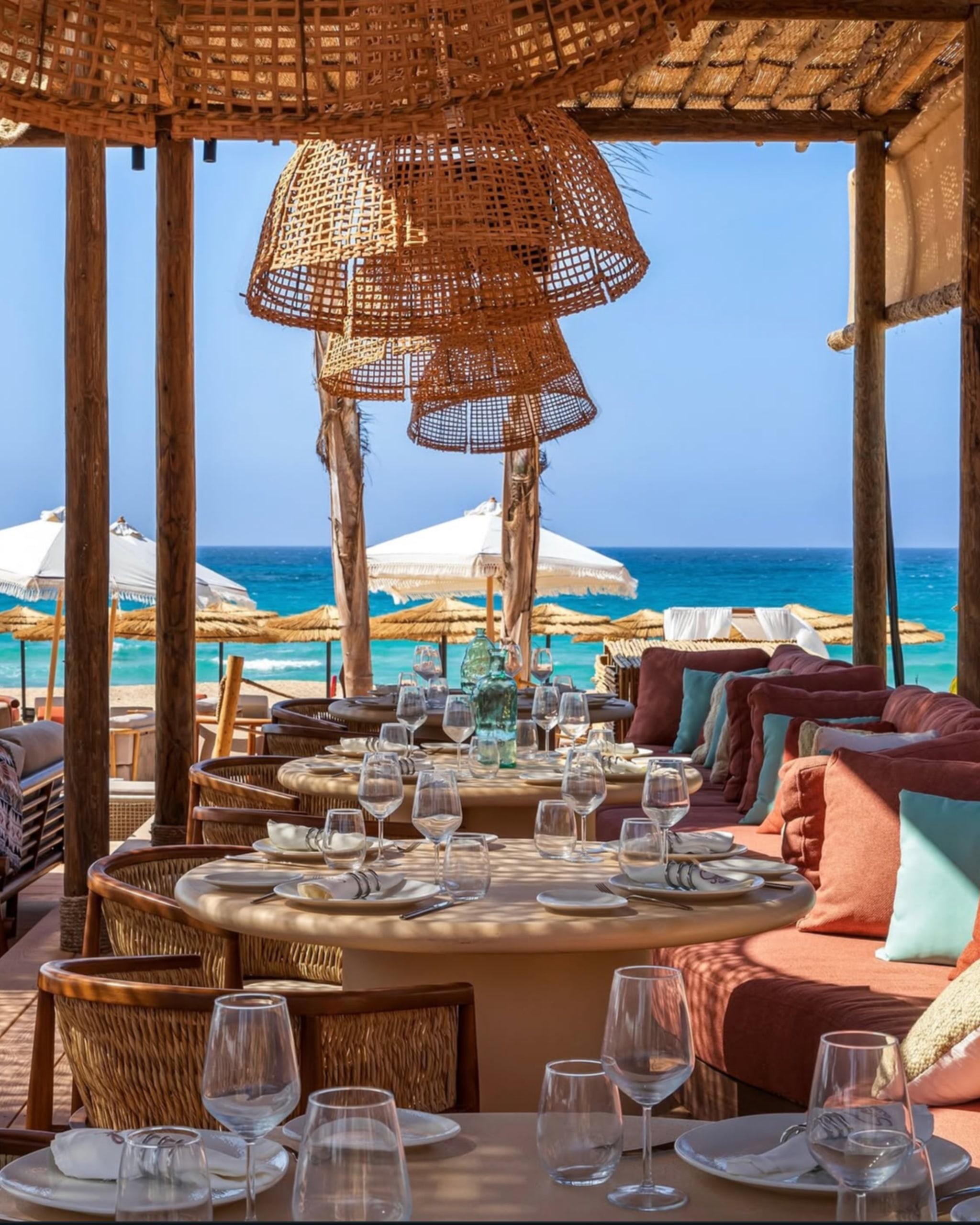 A shaded seafront restaurant with rattan lamps on the North Coast