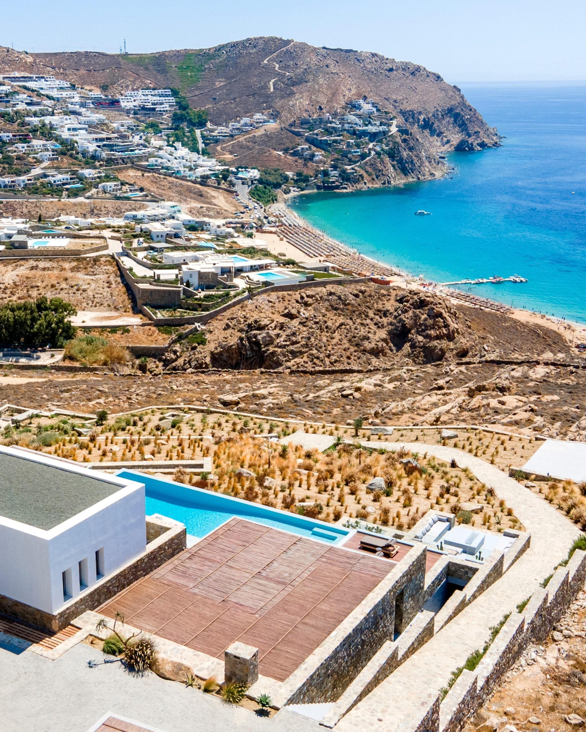 A hillside villa and pool above a bay on the Aegean coast