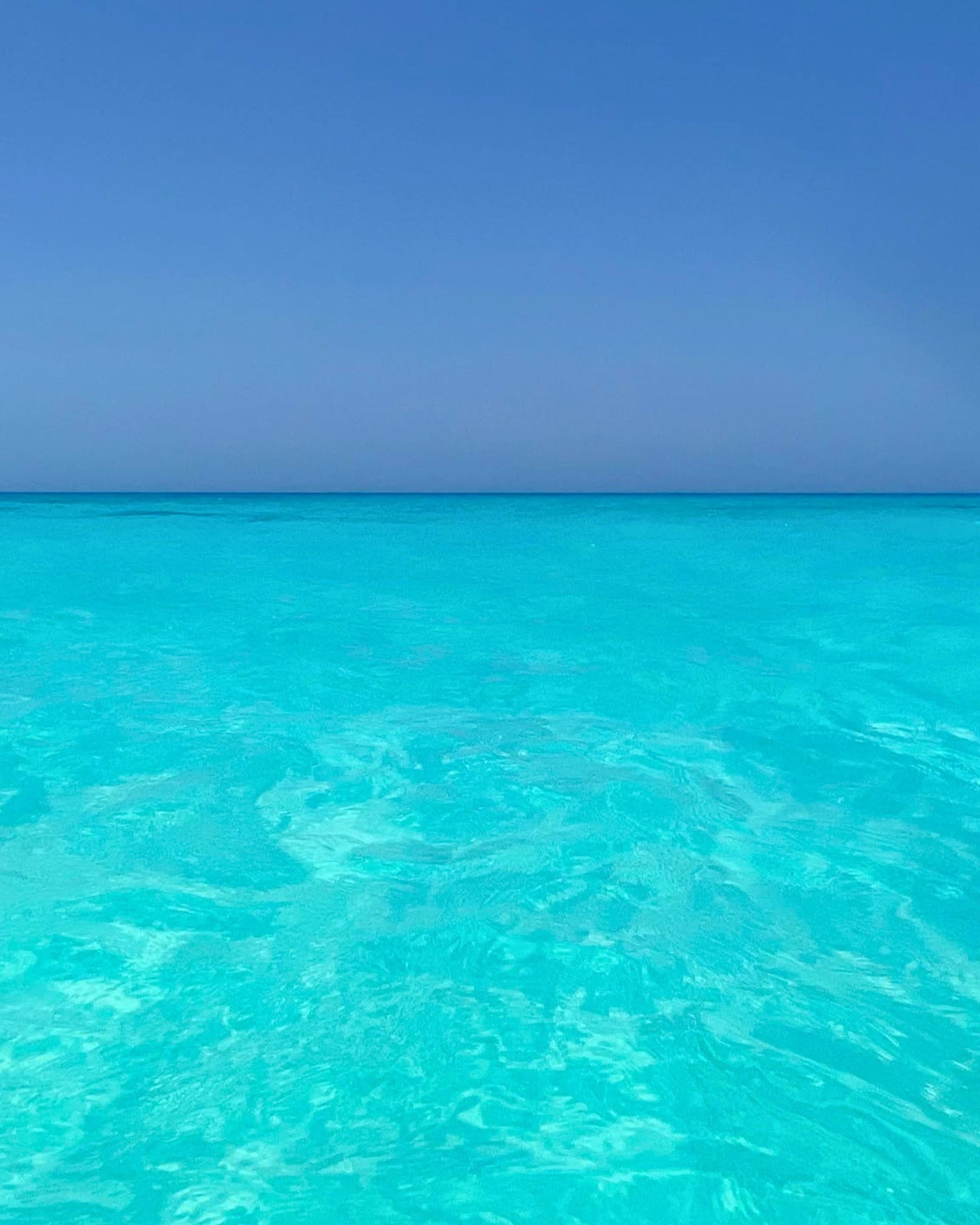 A calm turquoise sea meeting a clear sky