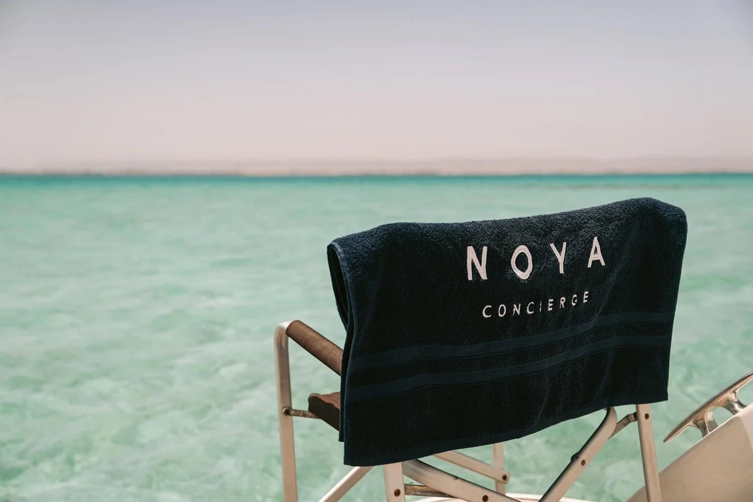 A NOYA director’s chair on a boat over clear water