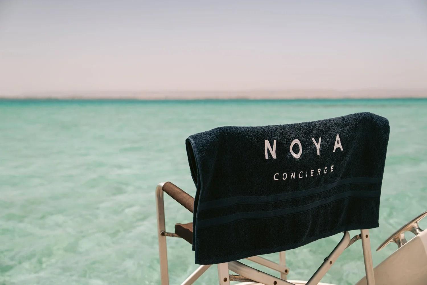 A NOYA director’s chair on a boat over clear water