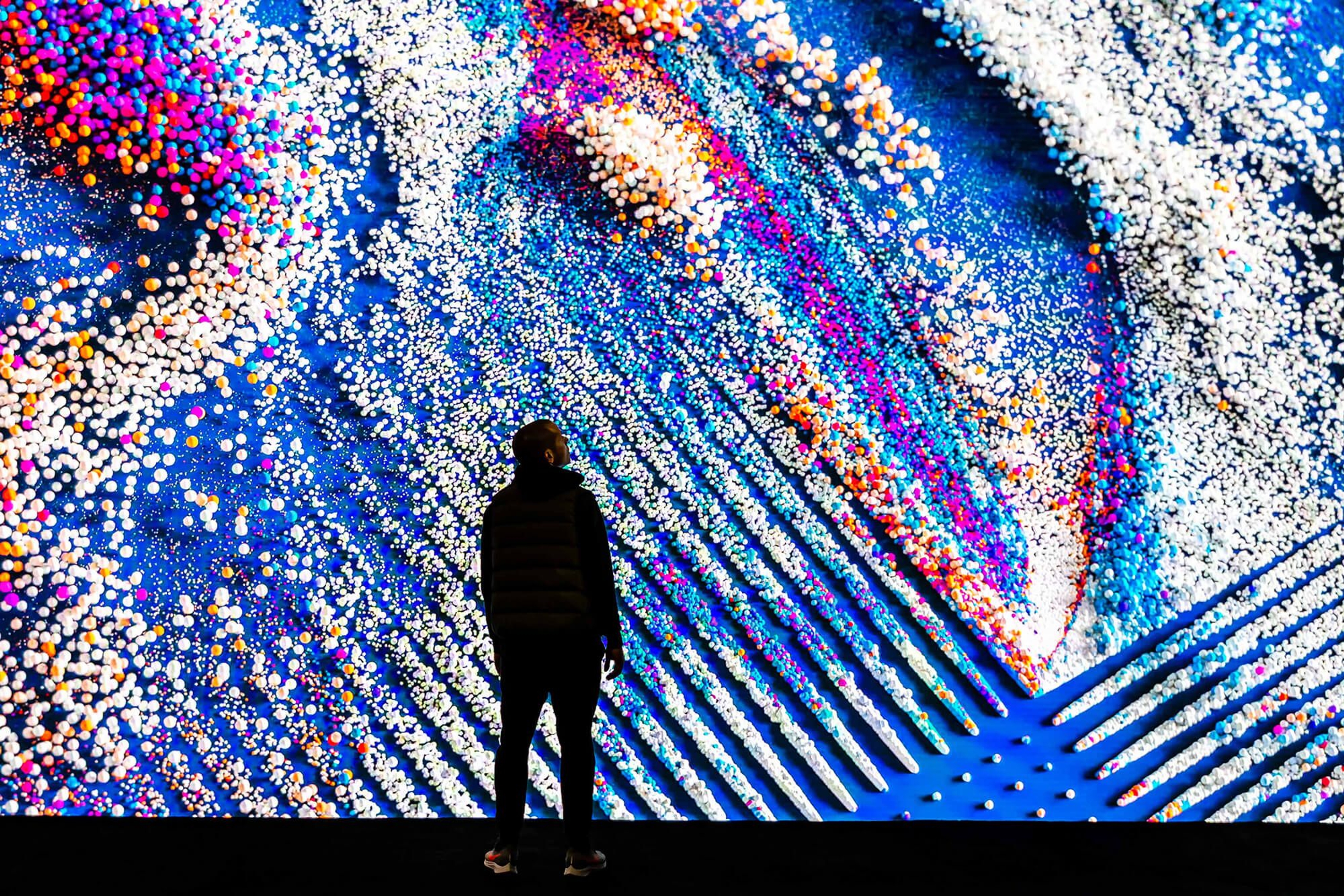 Photo of man in front of a large screen with a IBM think brand video