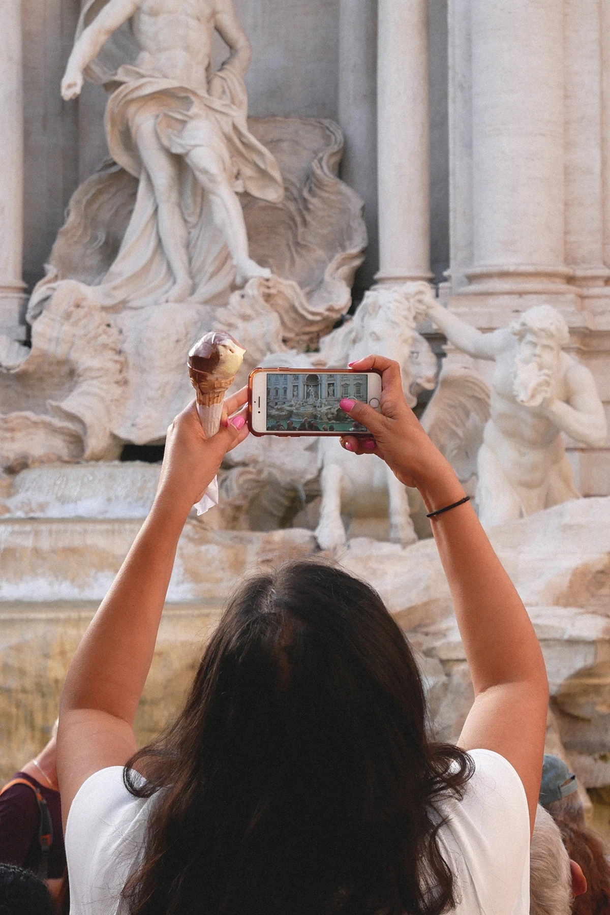 Woman taking picture of a fountain statue