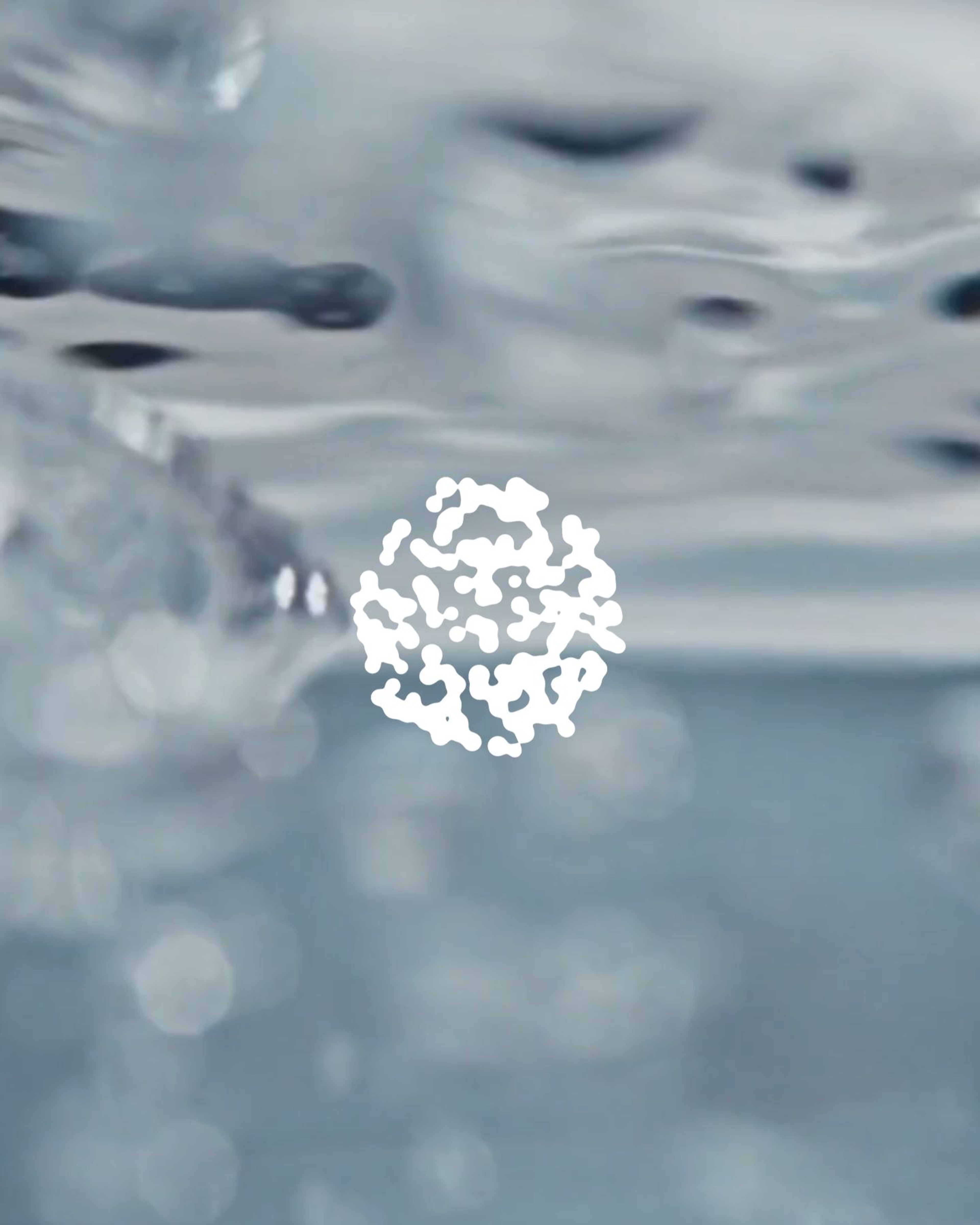 Organic shape made up of smaller elements in front of bubbles moving through liquid.