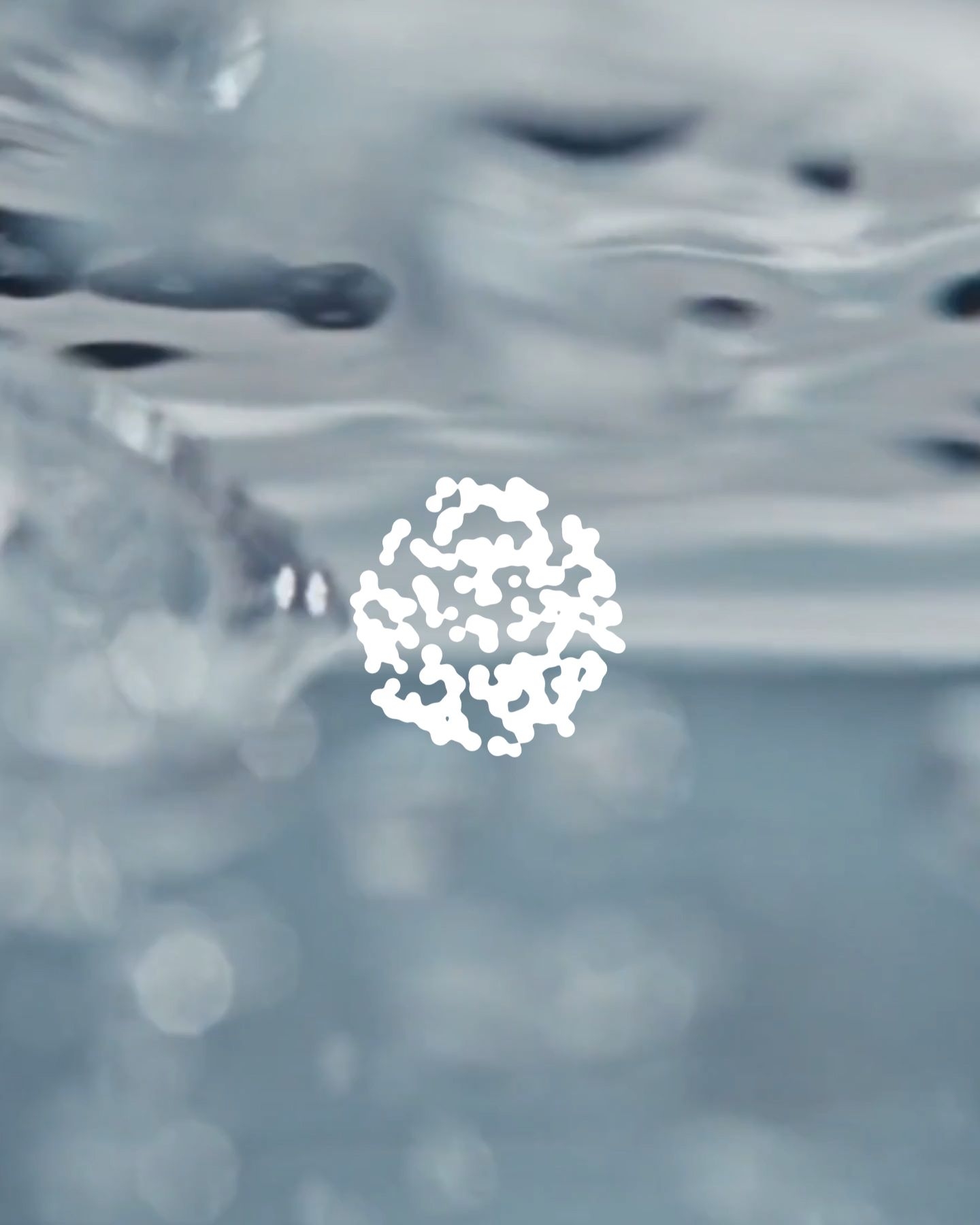 Organic shape made up of smaller elements in front of bubbles moving through liquid.