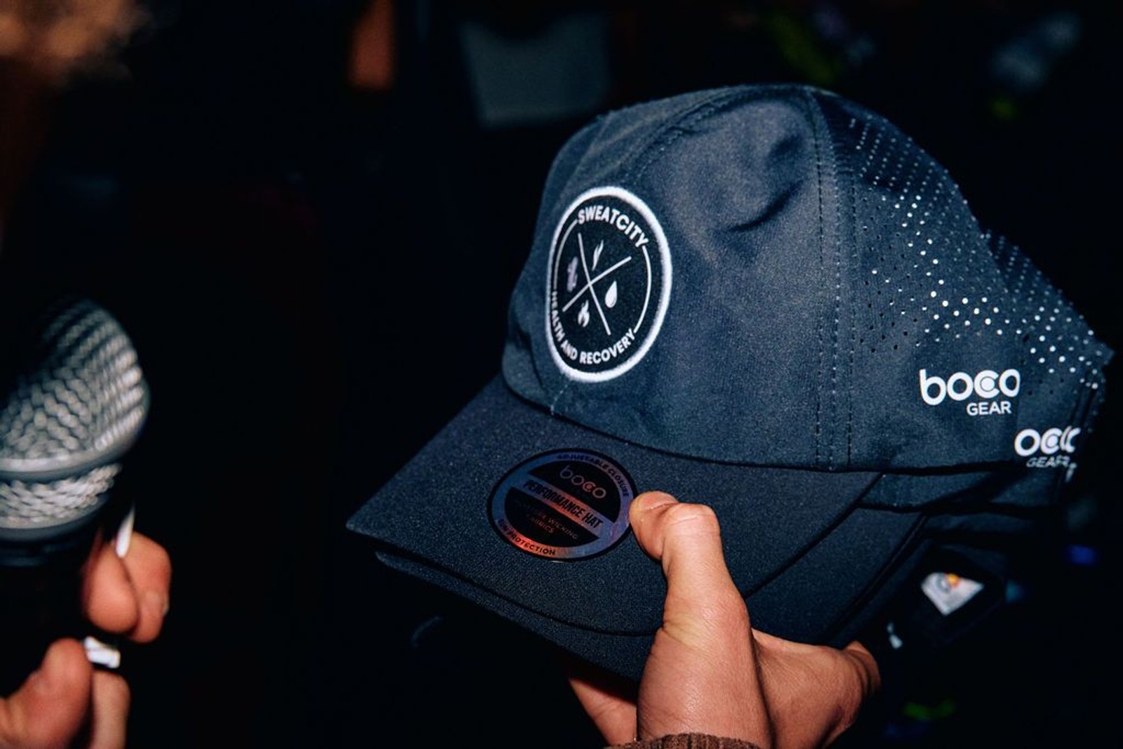 A Sweatcity ATX performance cap held up at an event