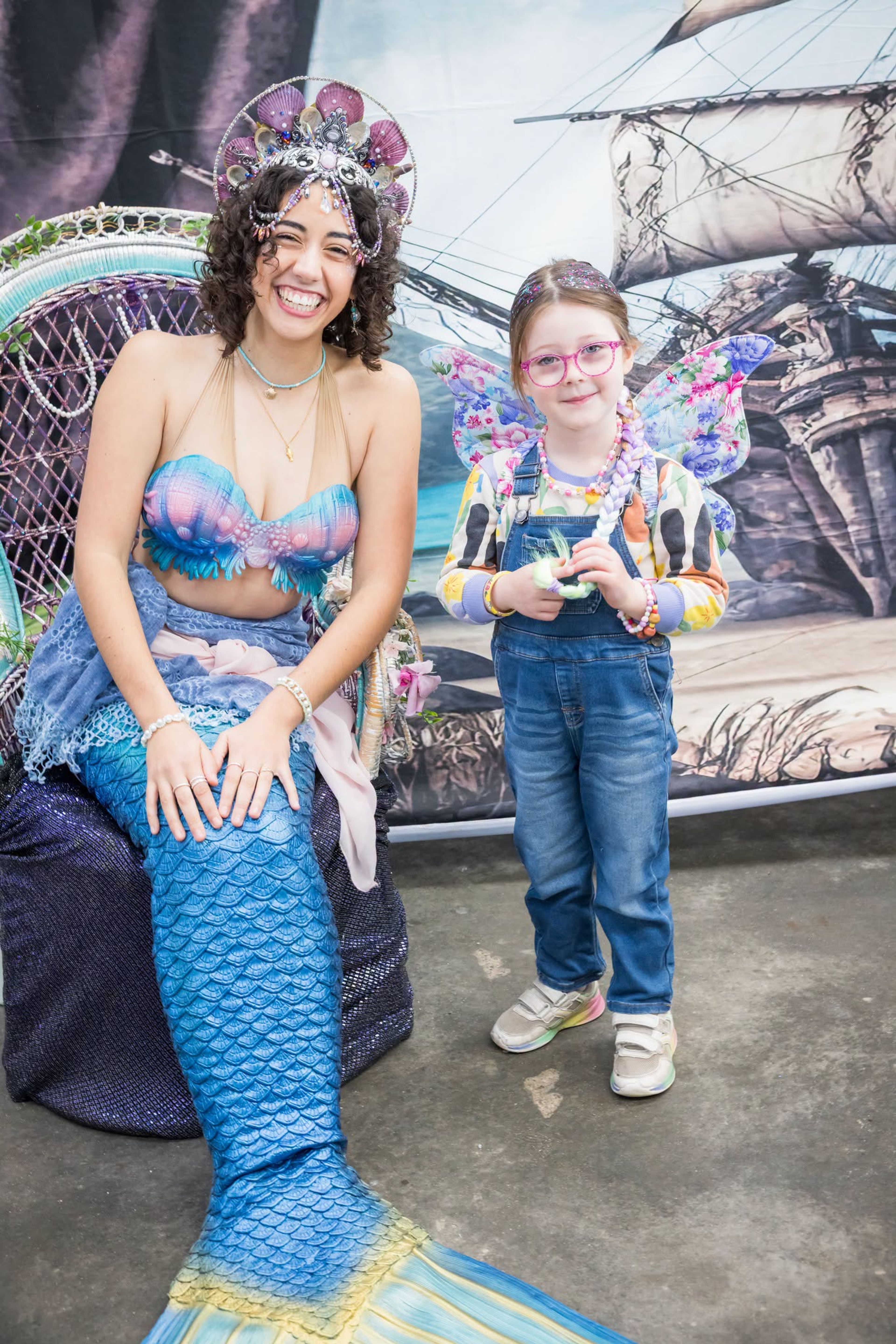 Little girl getting picture taken with mermaid