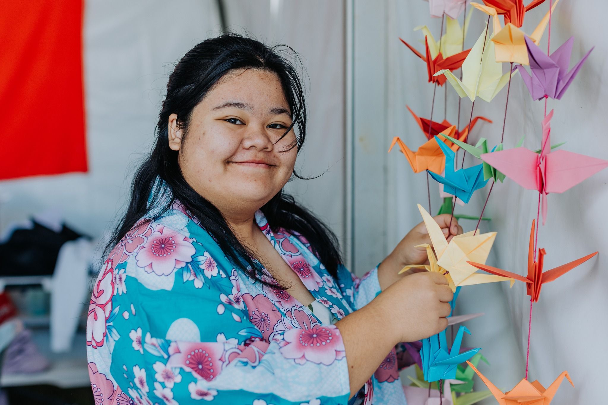 Woman stands with folder paper cranes