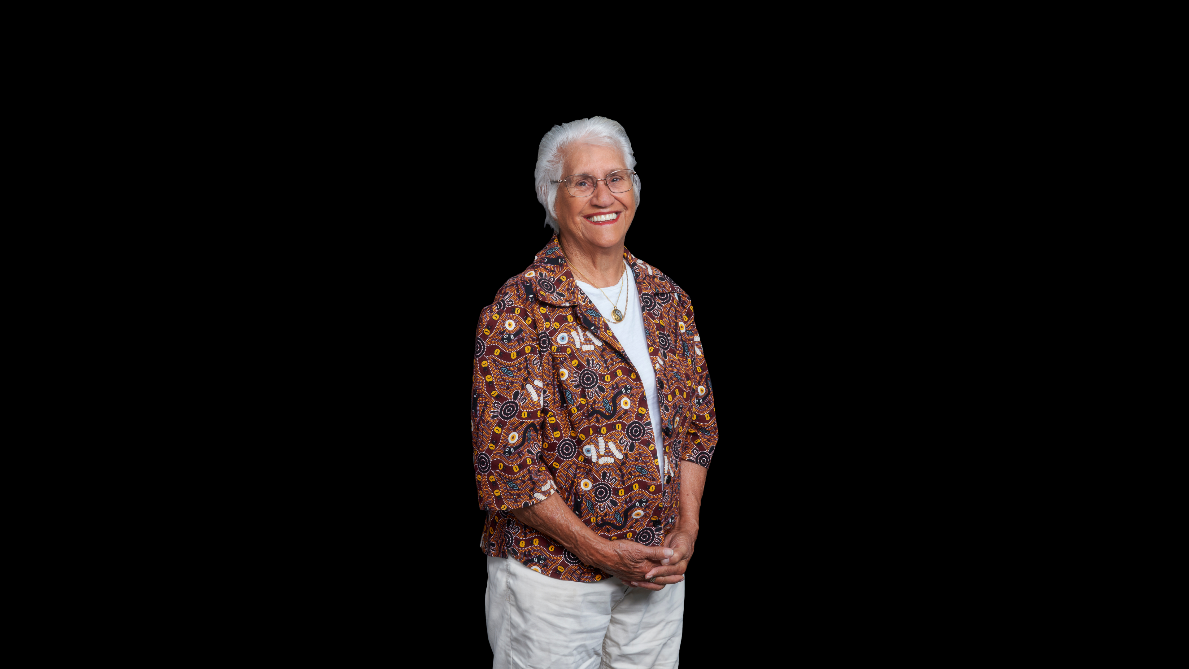 Older Noongar lady smiling on a black background