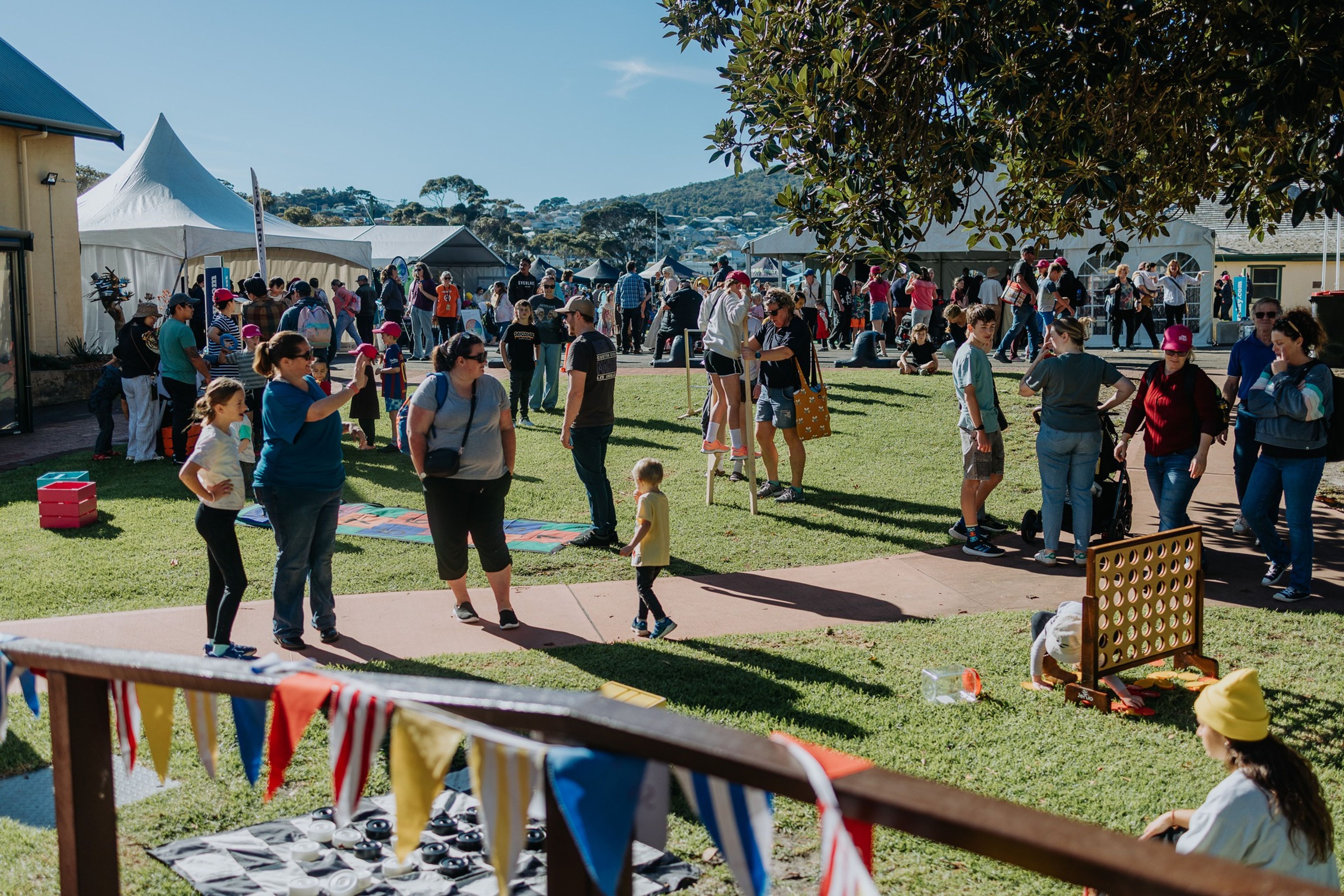 Festival photo featuring crowds, stalls and lawn games.