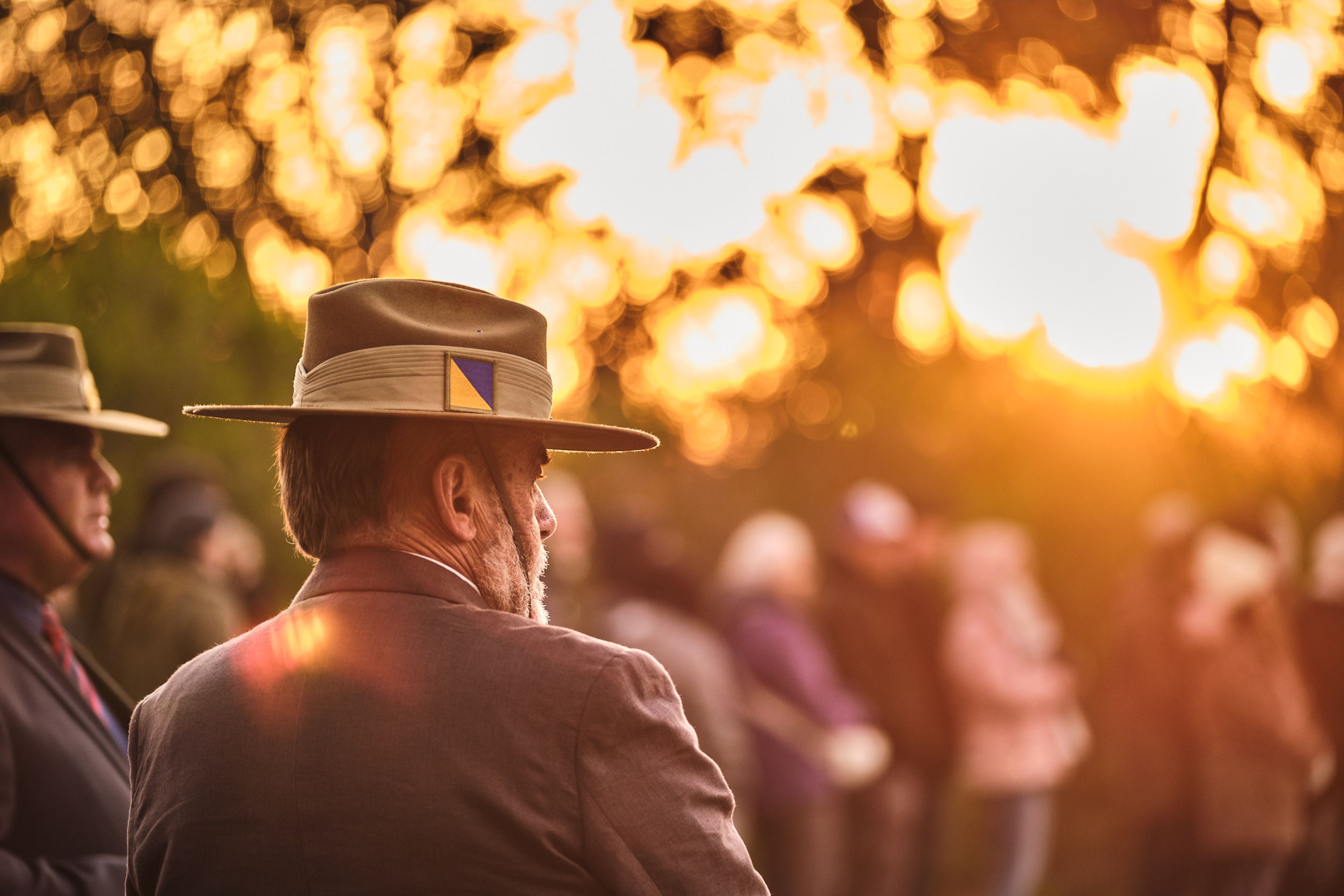 Man stands in military uniform before the glow of dawn