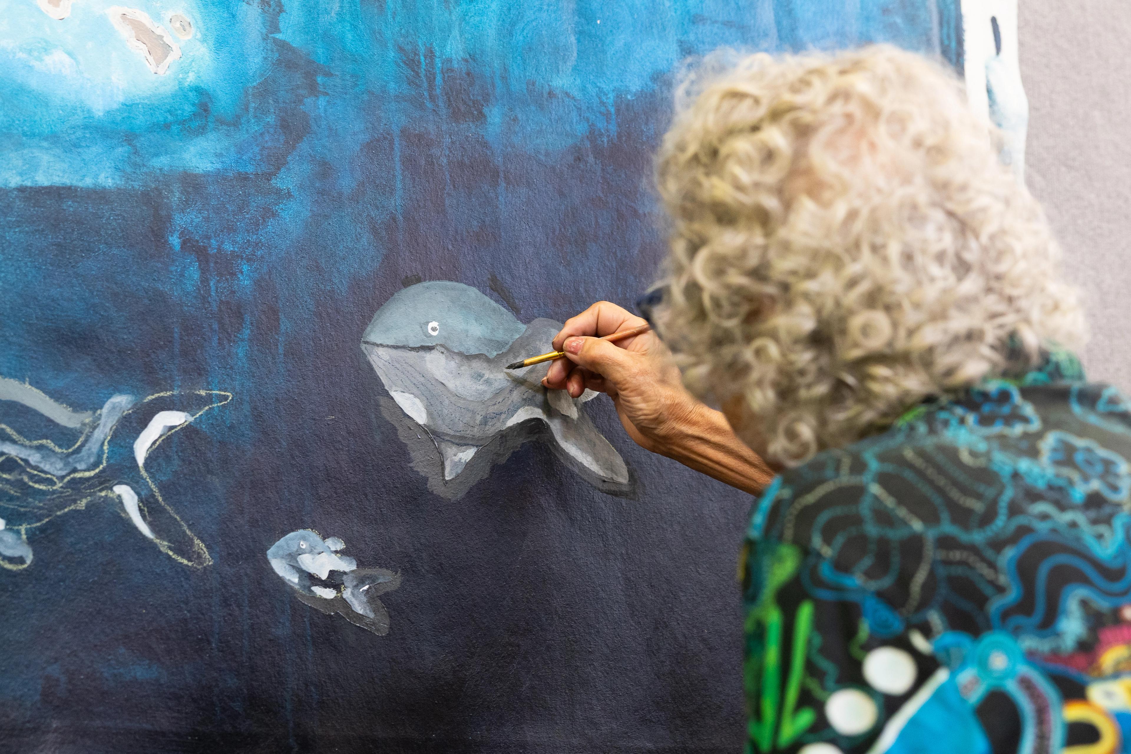 A photo of a person painting a whale