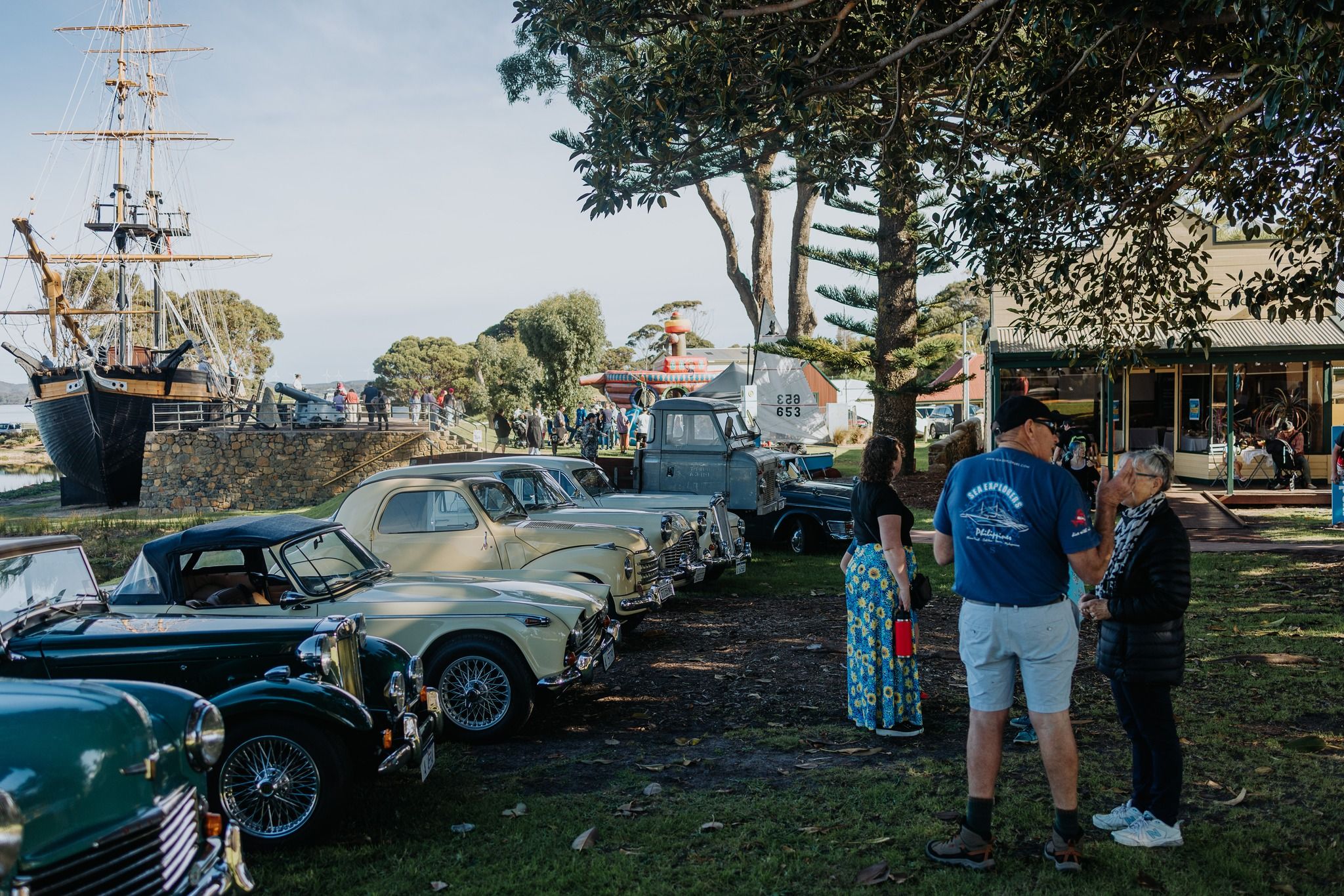 Vintage car display with bouncy castle and The Amity in the background