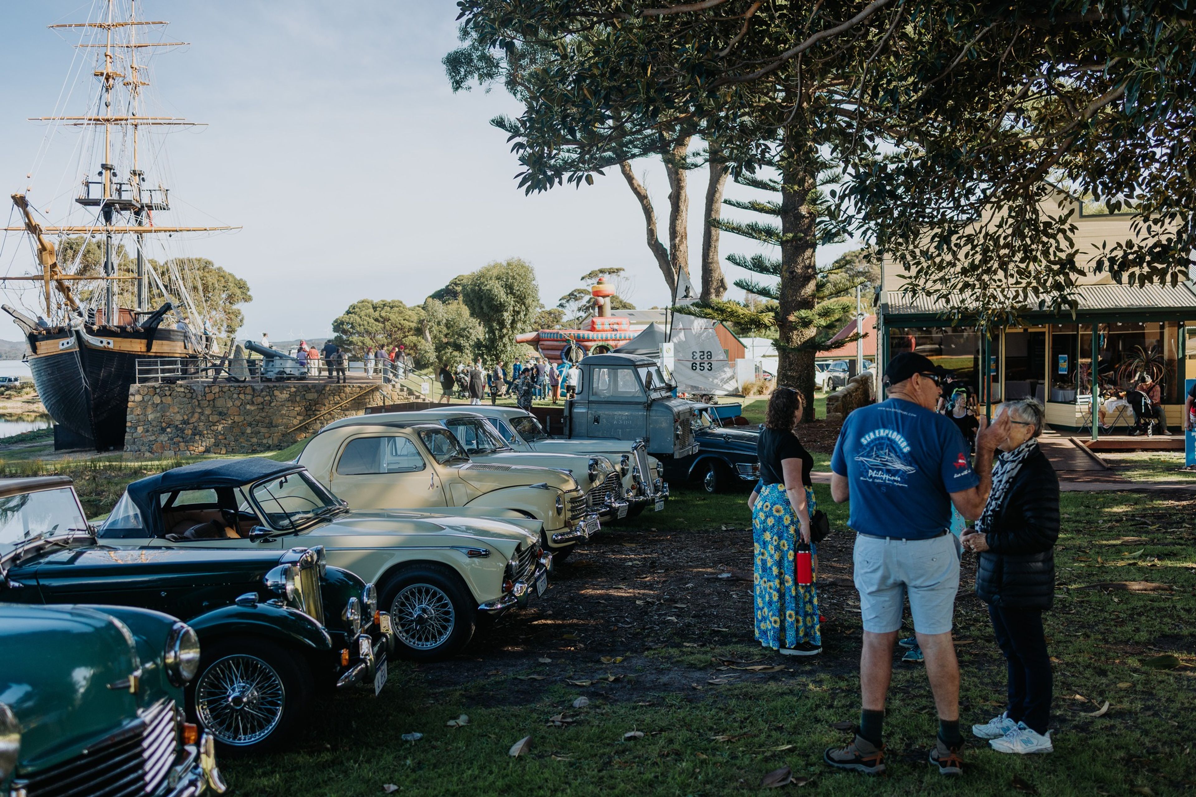 Vintage car display with bouncy castle and The Amity in the background