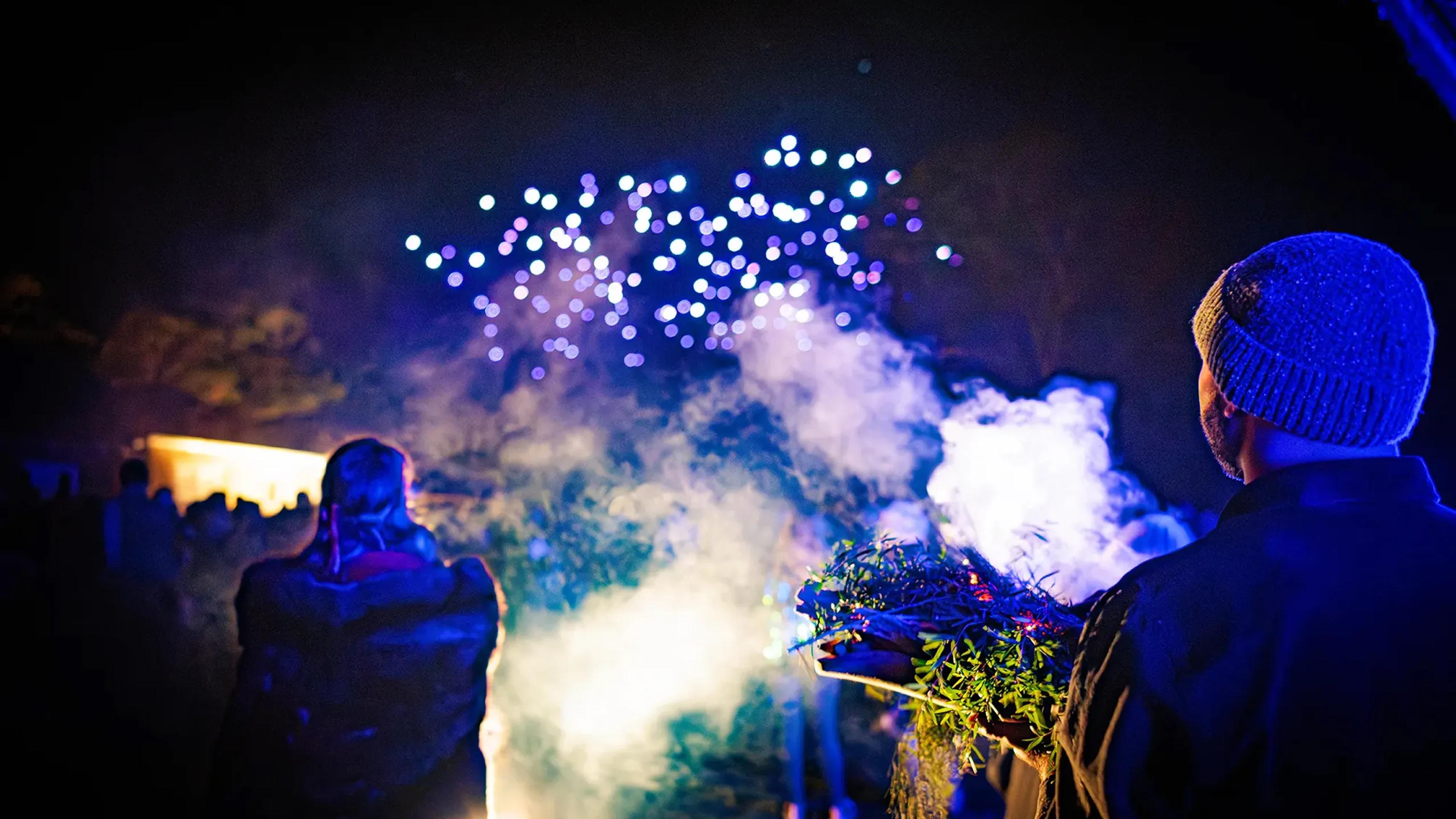 A photo of a man and a woman standing in front of a smoking ceremony.