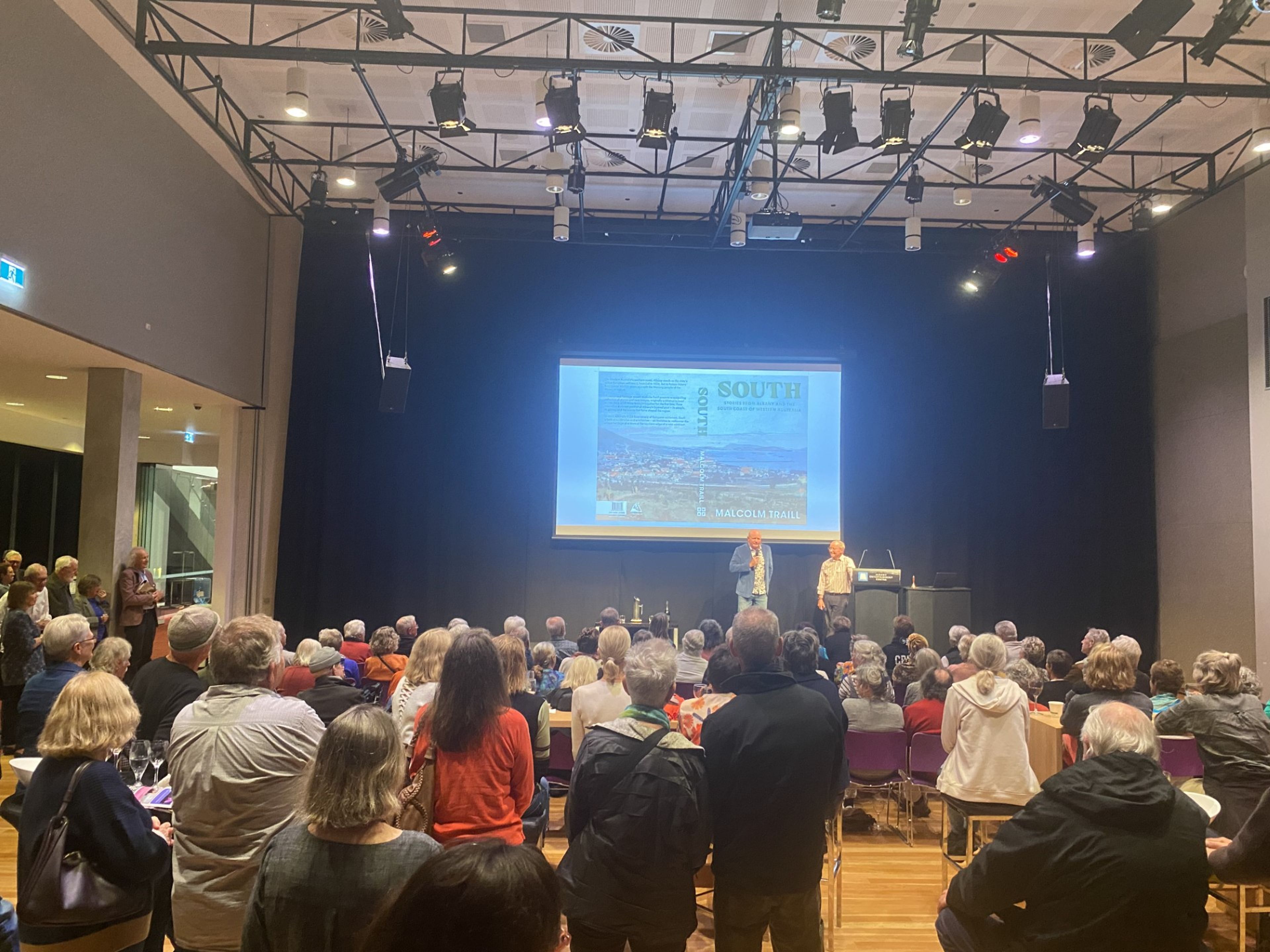 A image of a crowded room, gathered for a book launch