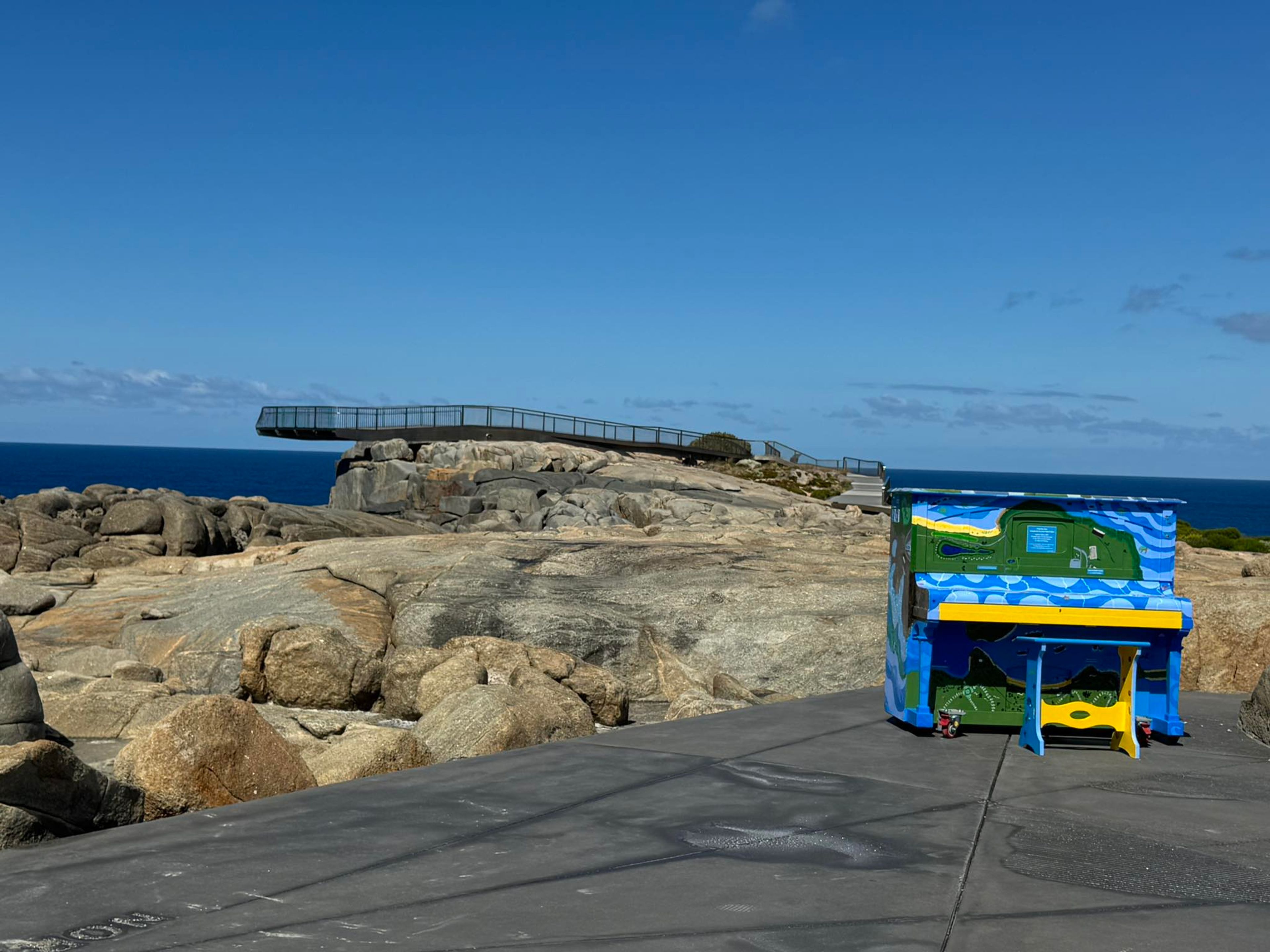 A brightly painted piano sits in front of The Gap