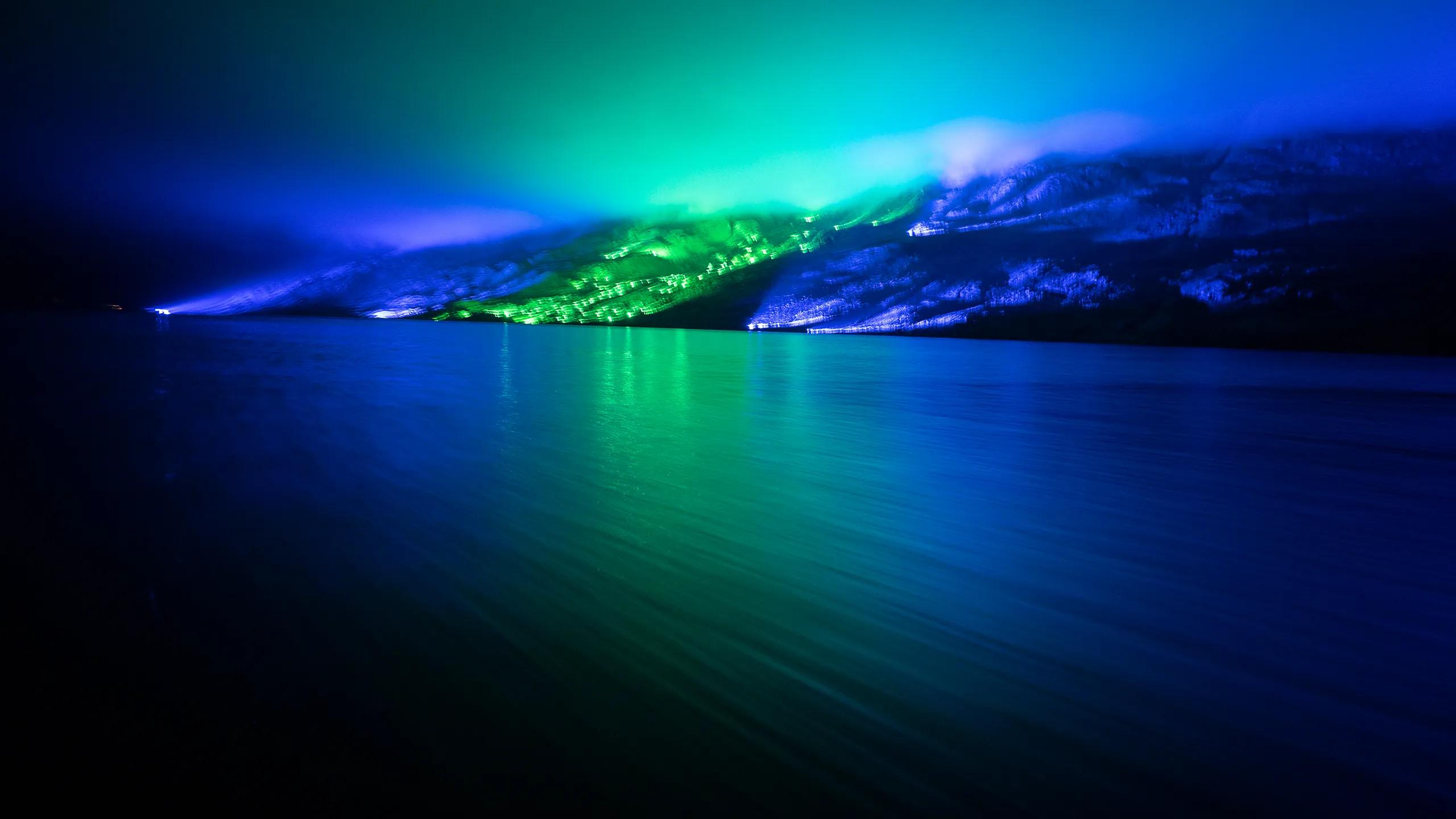 A photo of Albany at night time with the southern lights in full display above.