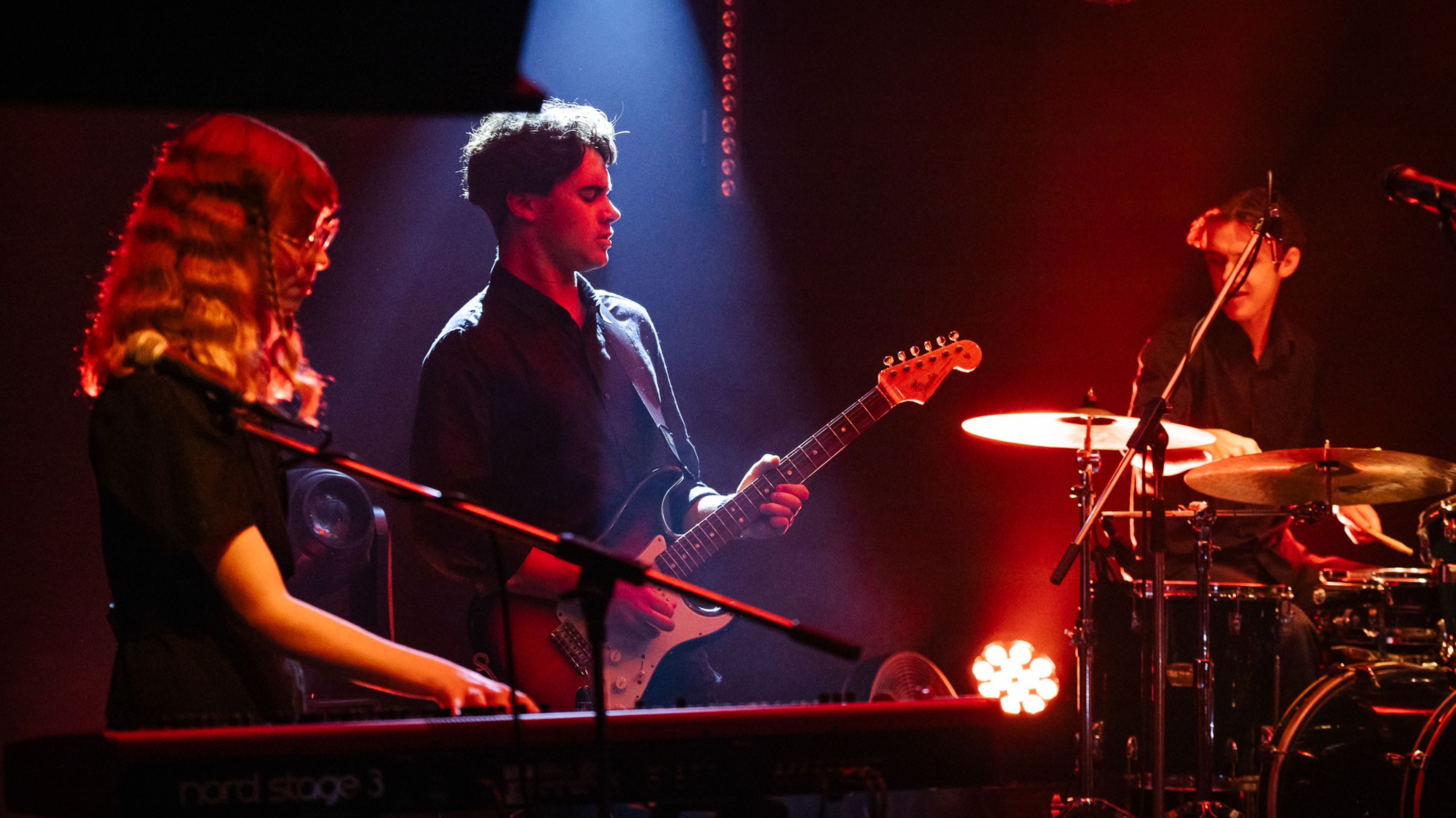 Musicians perform under moody lighting