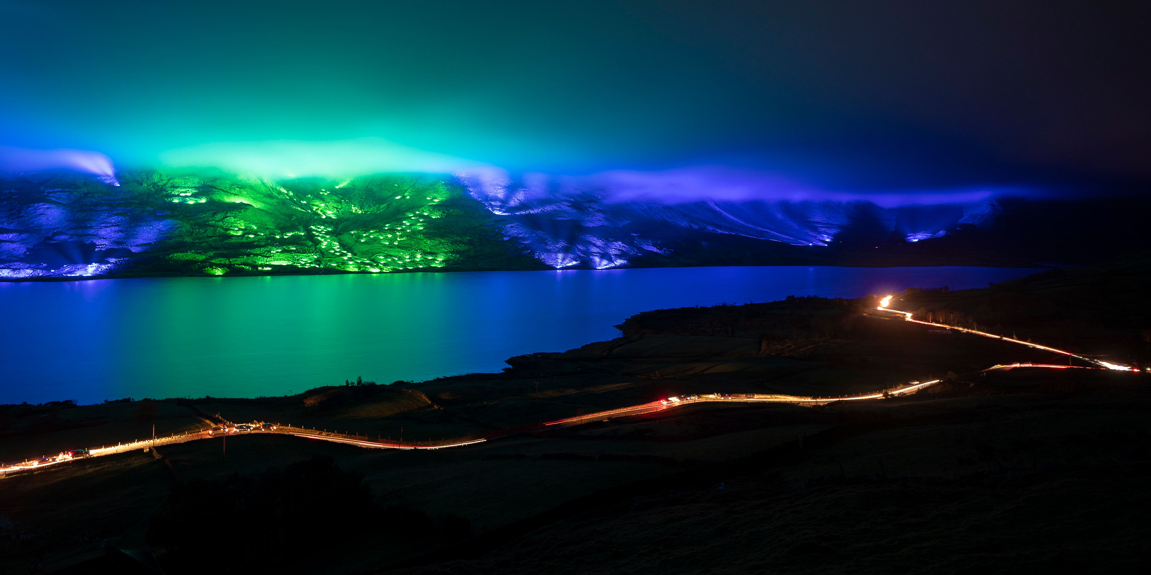 Hillside illuminated in green and blue light