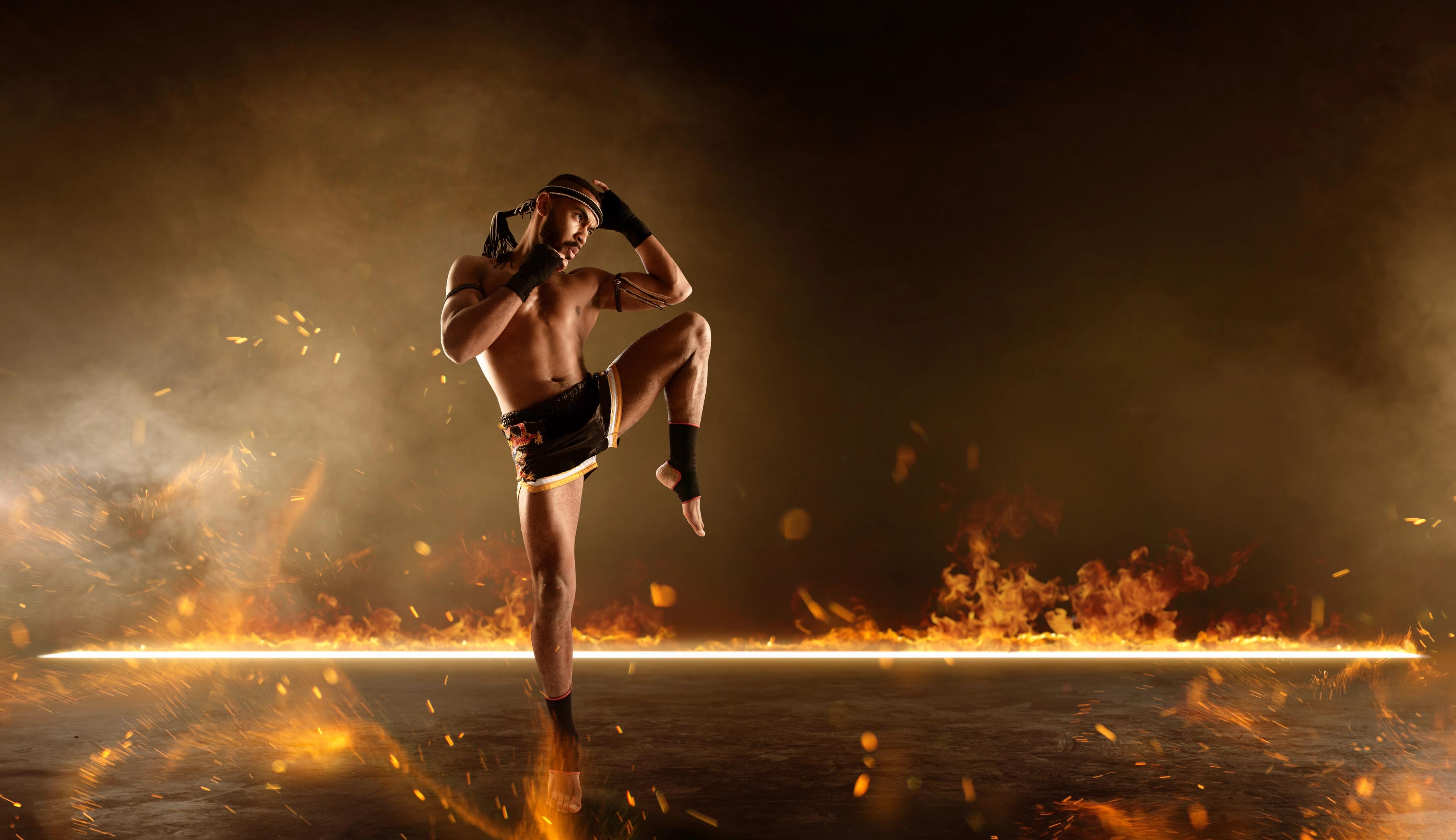 Muay Thai fighter before a fiery backdrop