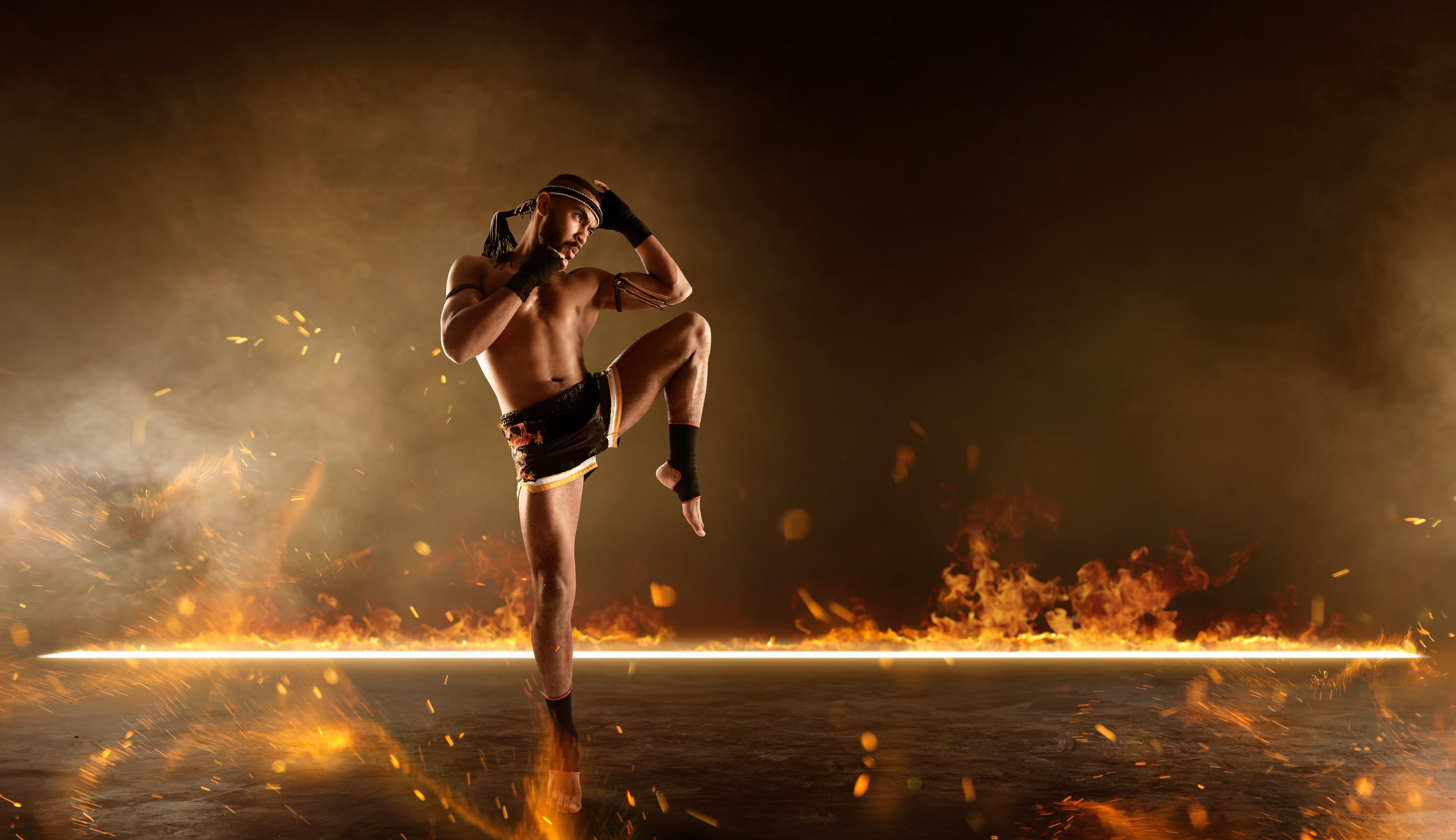 Muay Thai fighter before a fiery backdrop