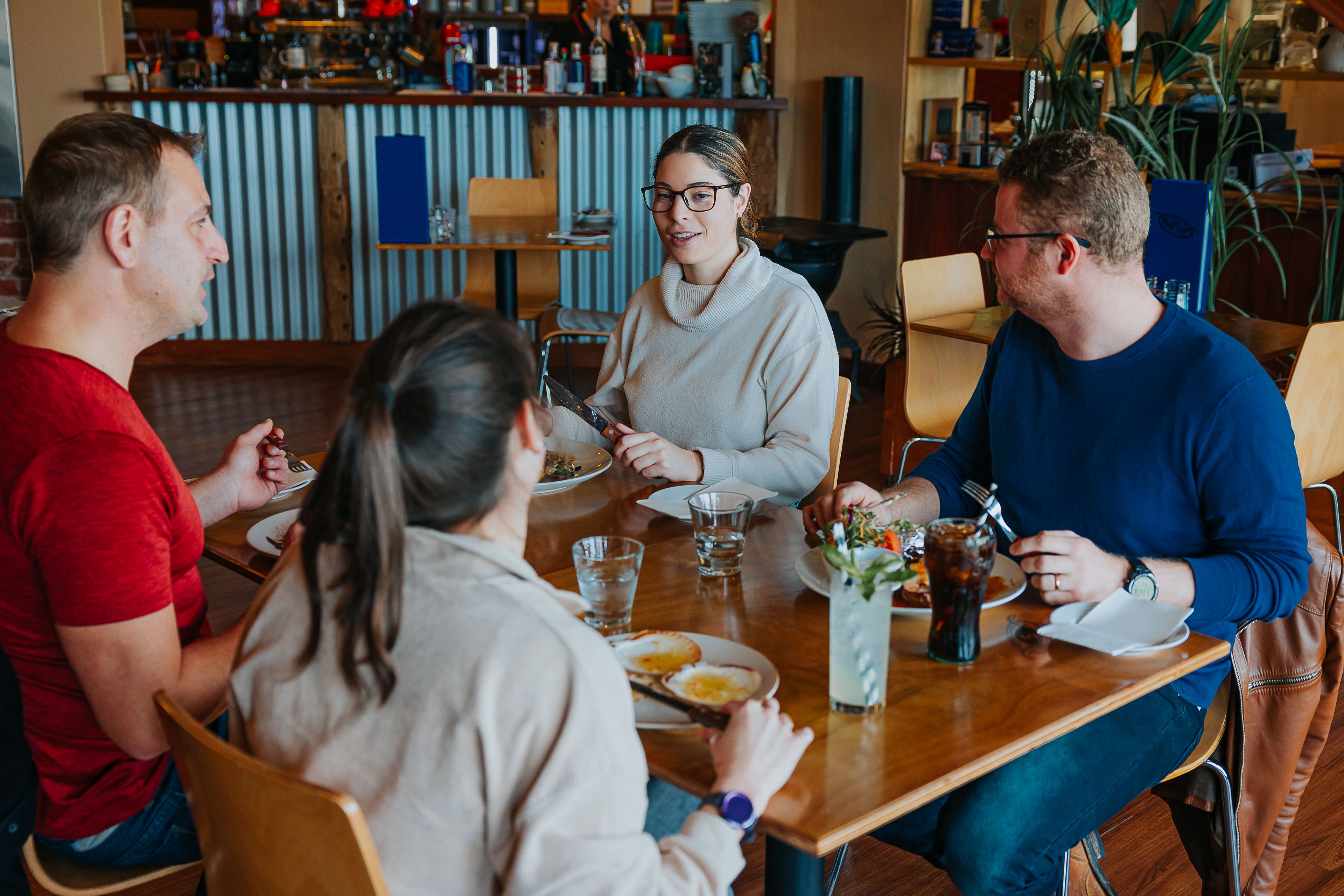A group of friends sit together at Rustler's Steakhouse and Grill.