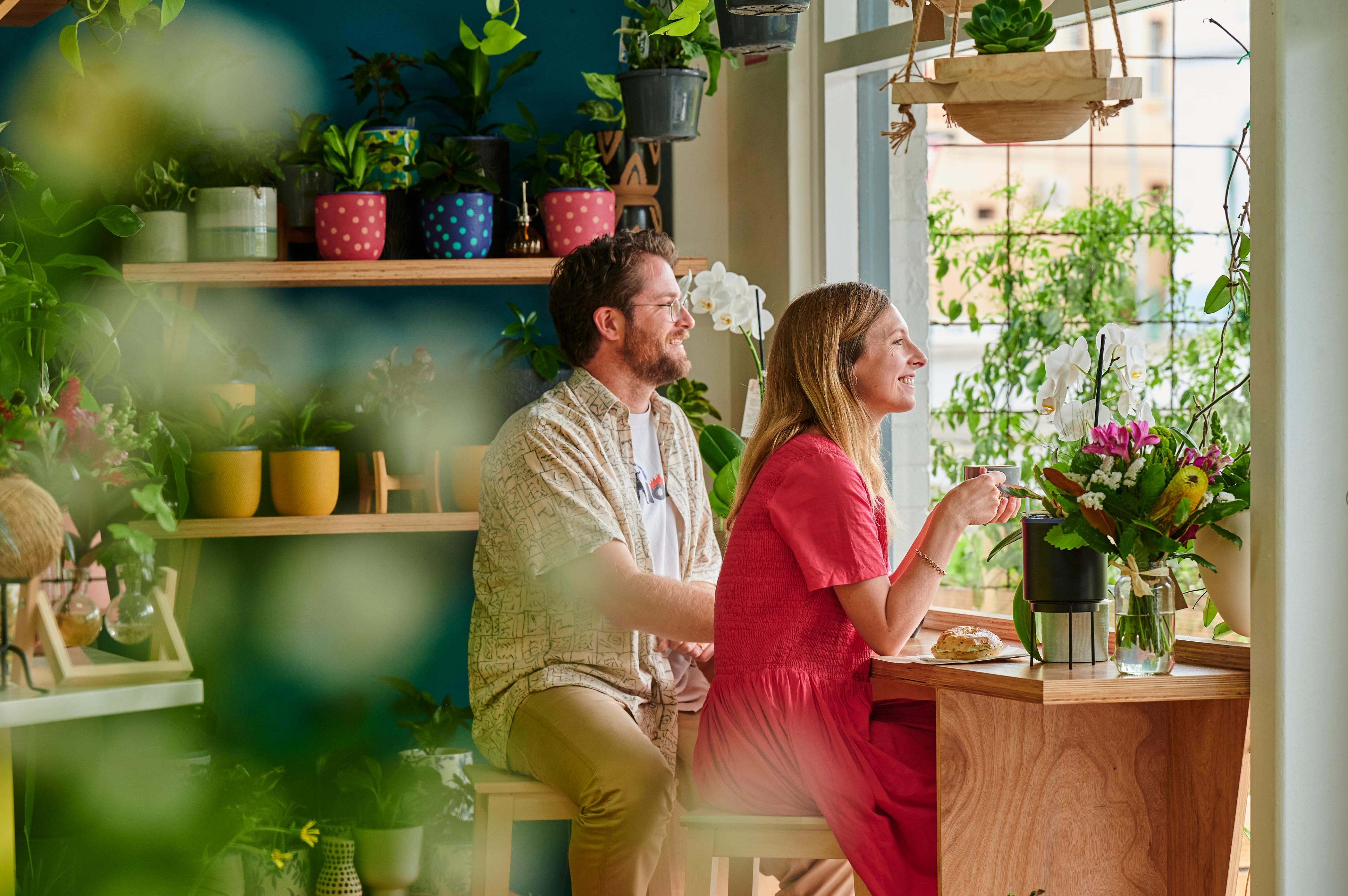 A couple surrounded by plants, enjoying a coffee in Albany's La Botanic