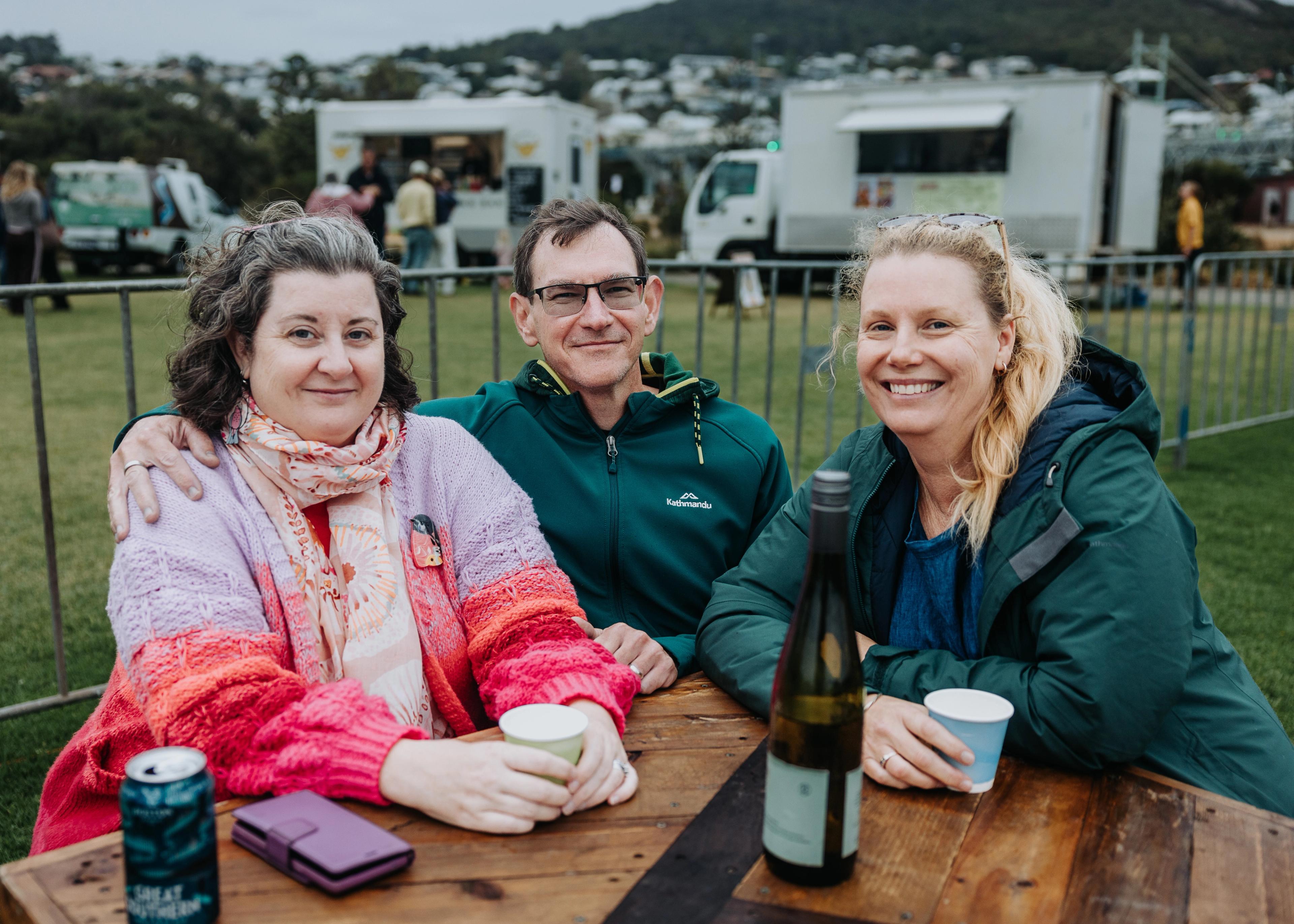 Three people sit smiling at an event