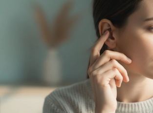Donna che si tocca l’orecchio con espressione assorta