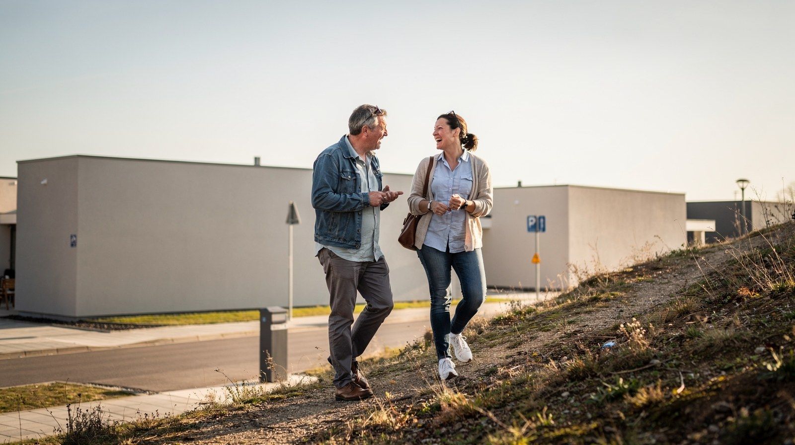 Due persone salgono insieme un sentiero in collina, chiacchierando.