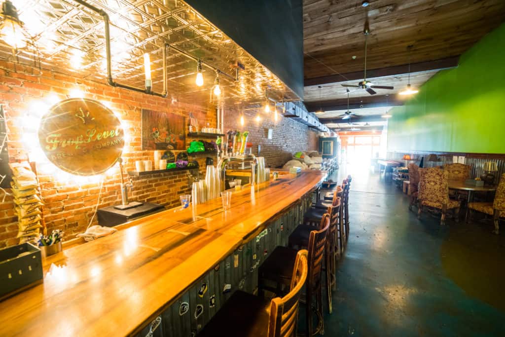 The empty bar at Frog Level Brewing, with a backlit sign behind the bar