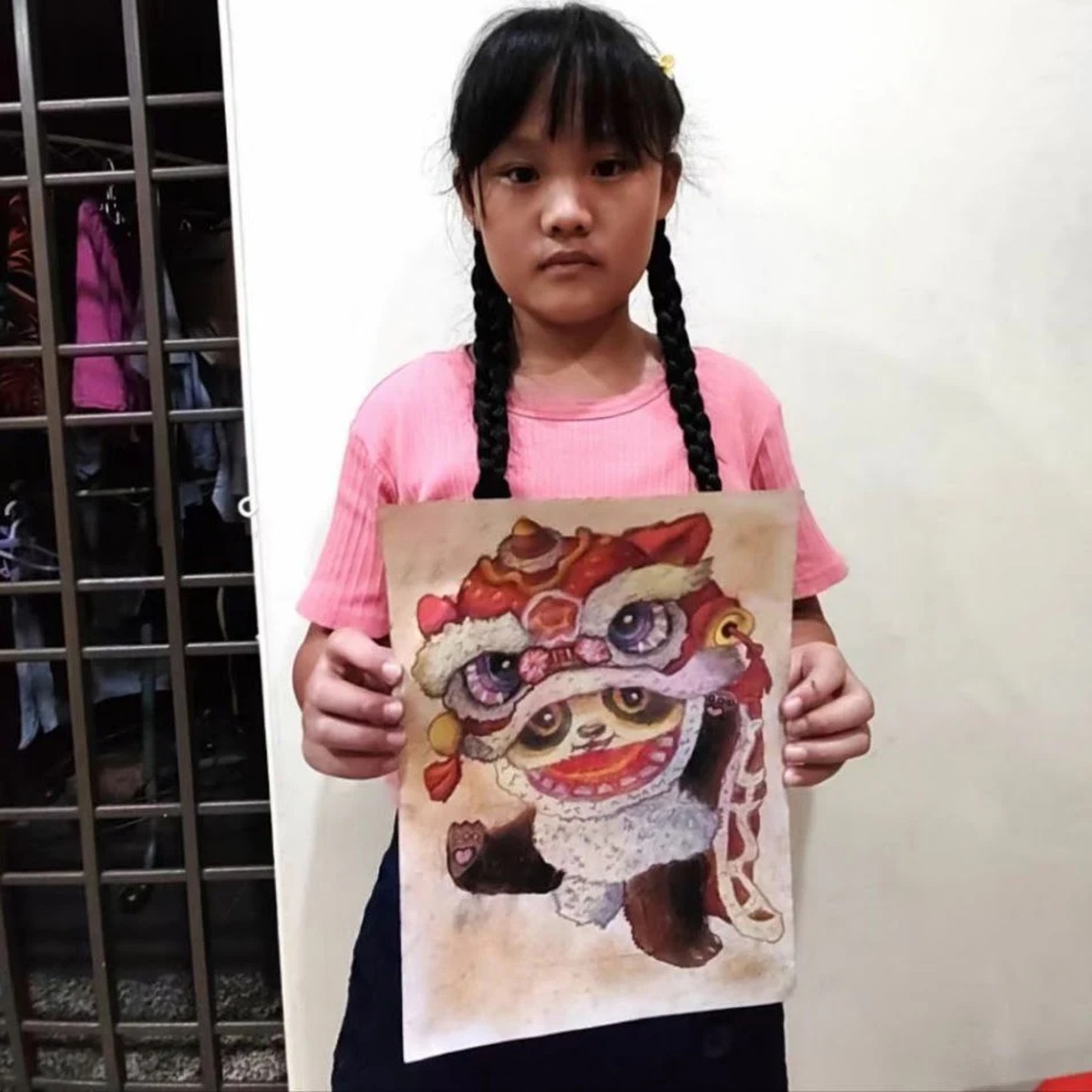 Student holding a traditional lion dance drawing