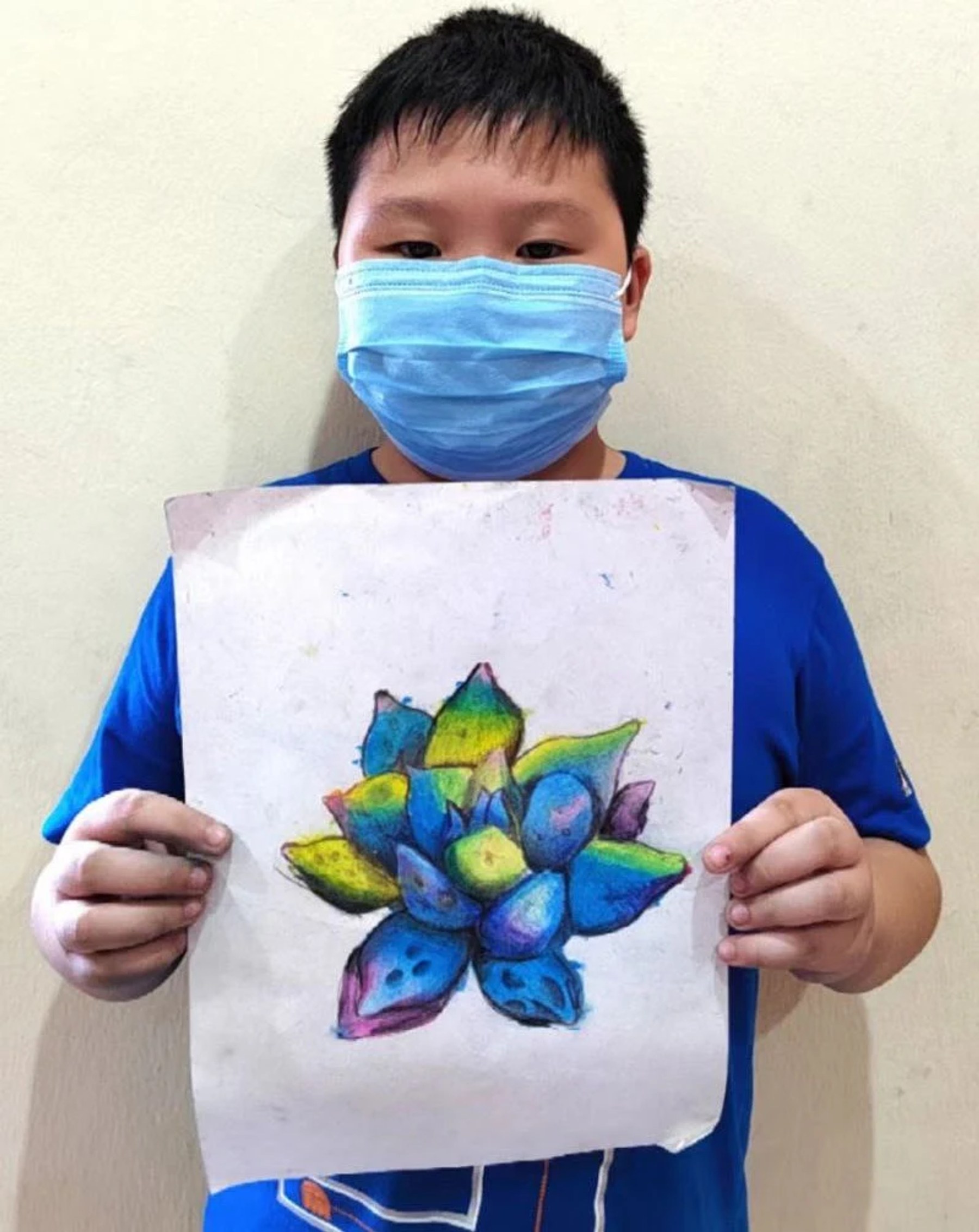 Student holding a brightly coloured succulent drawing