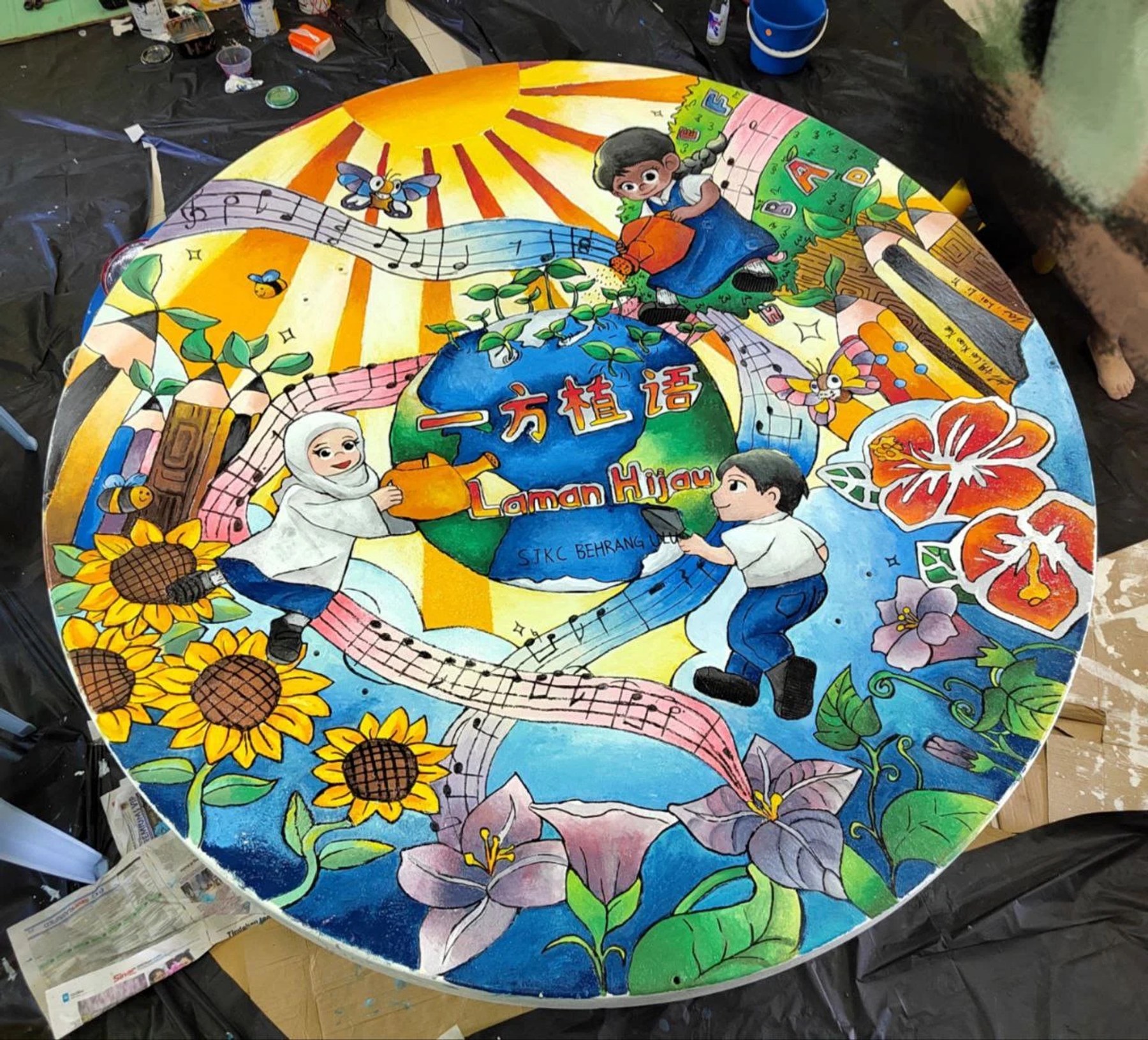 Completed circular mural with figures, sunflowers and Malaysian community scenes
