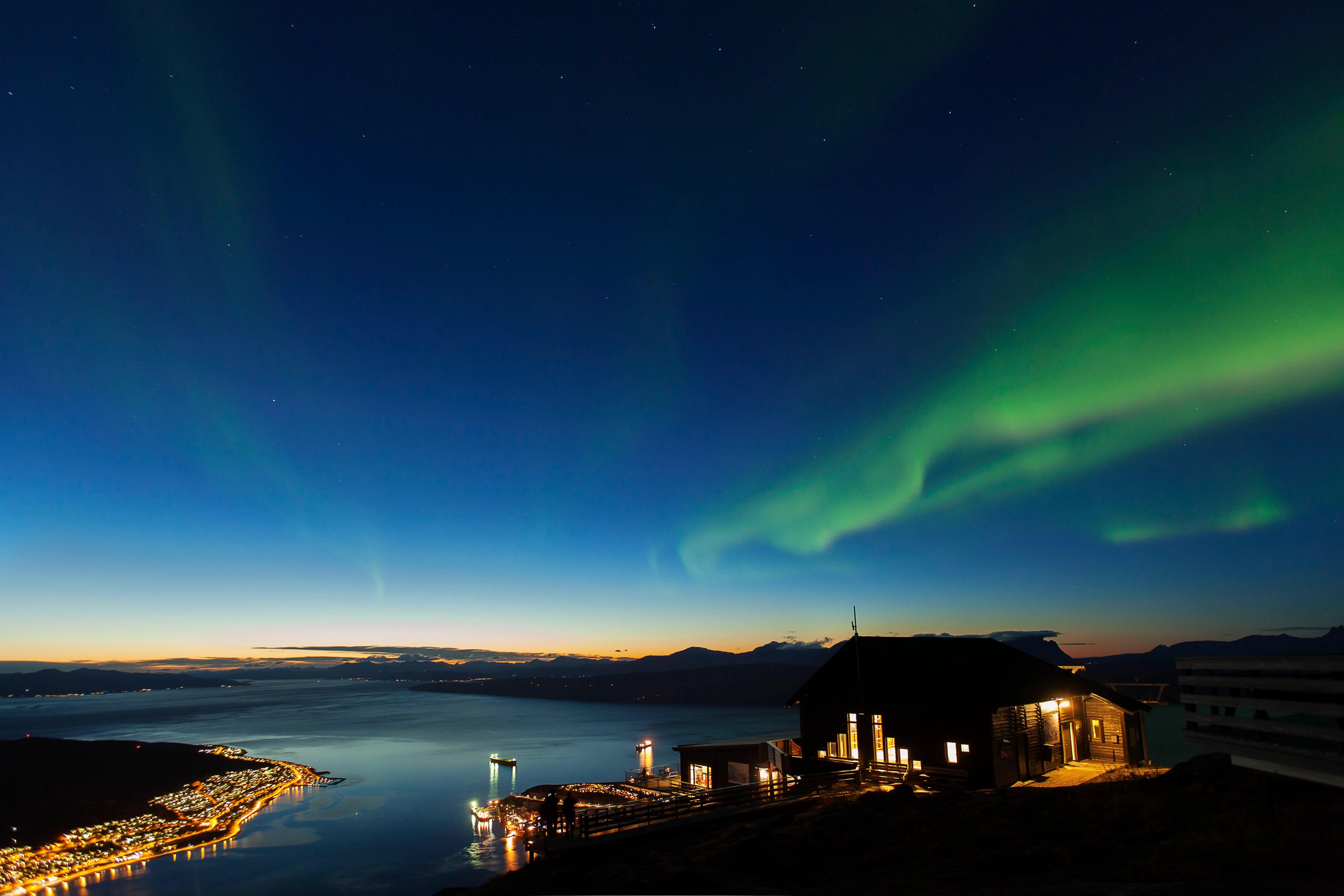 Aurora seen above the Fjellheis restaurant and the fjord.