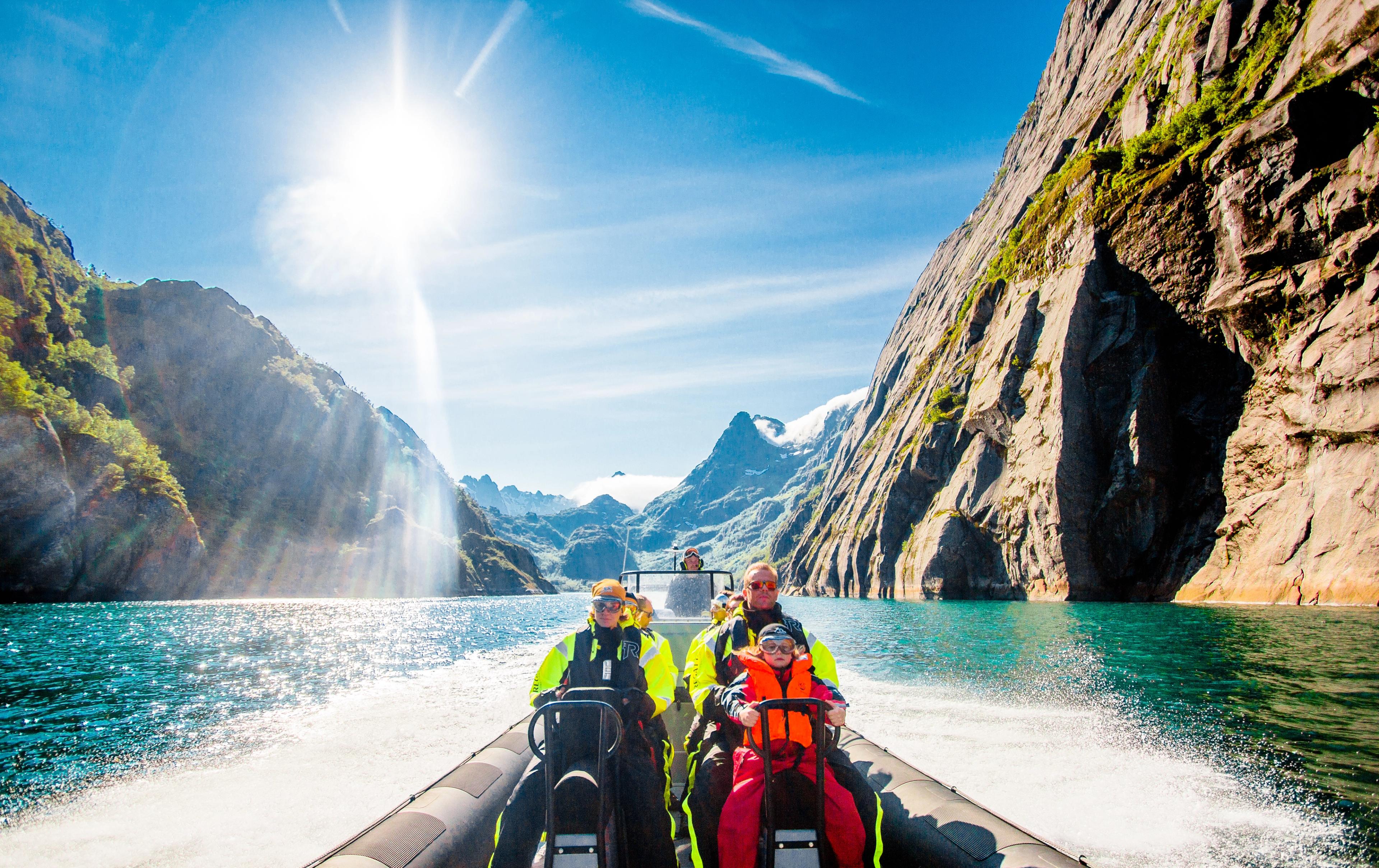 Turister som kjører ribbåt i trollfjorden på en nydelig sommerdag