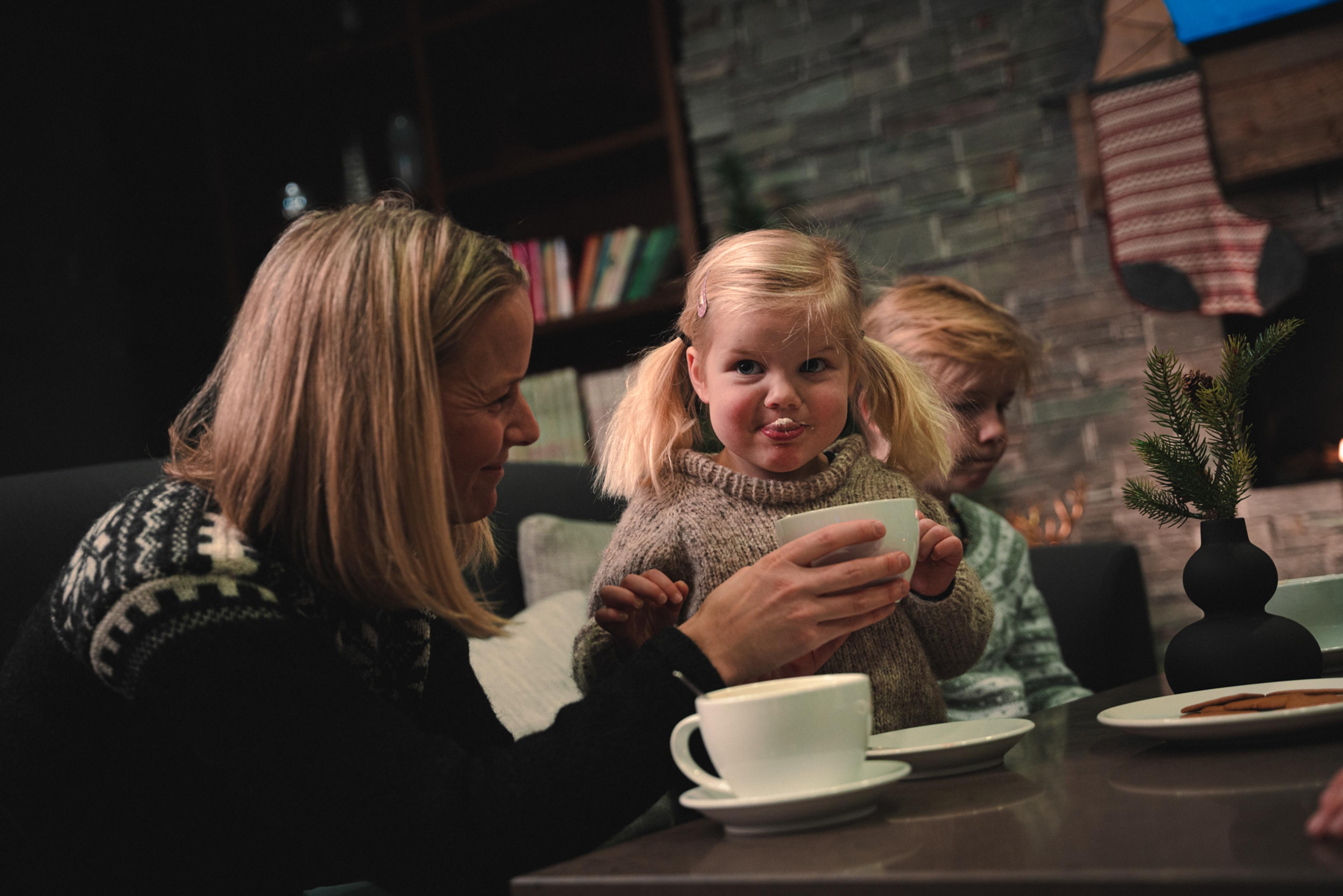 A mother and daughter drink cocoa