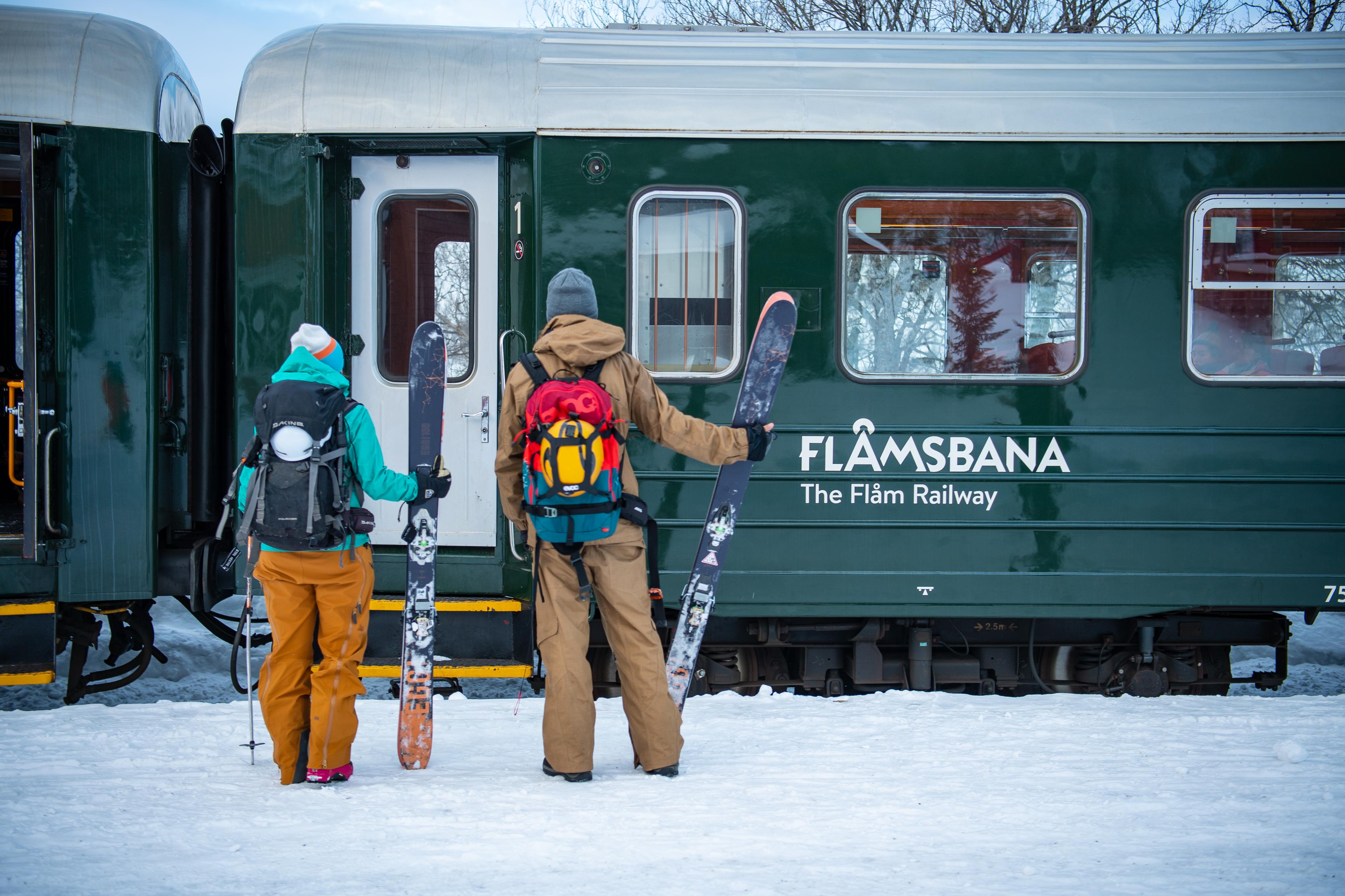 Et par med fjellski og turutstyr skal gå om bord Flåmsbana.