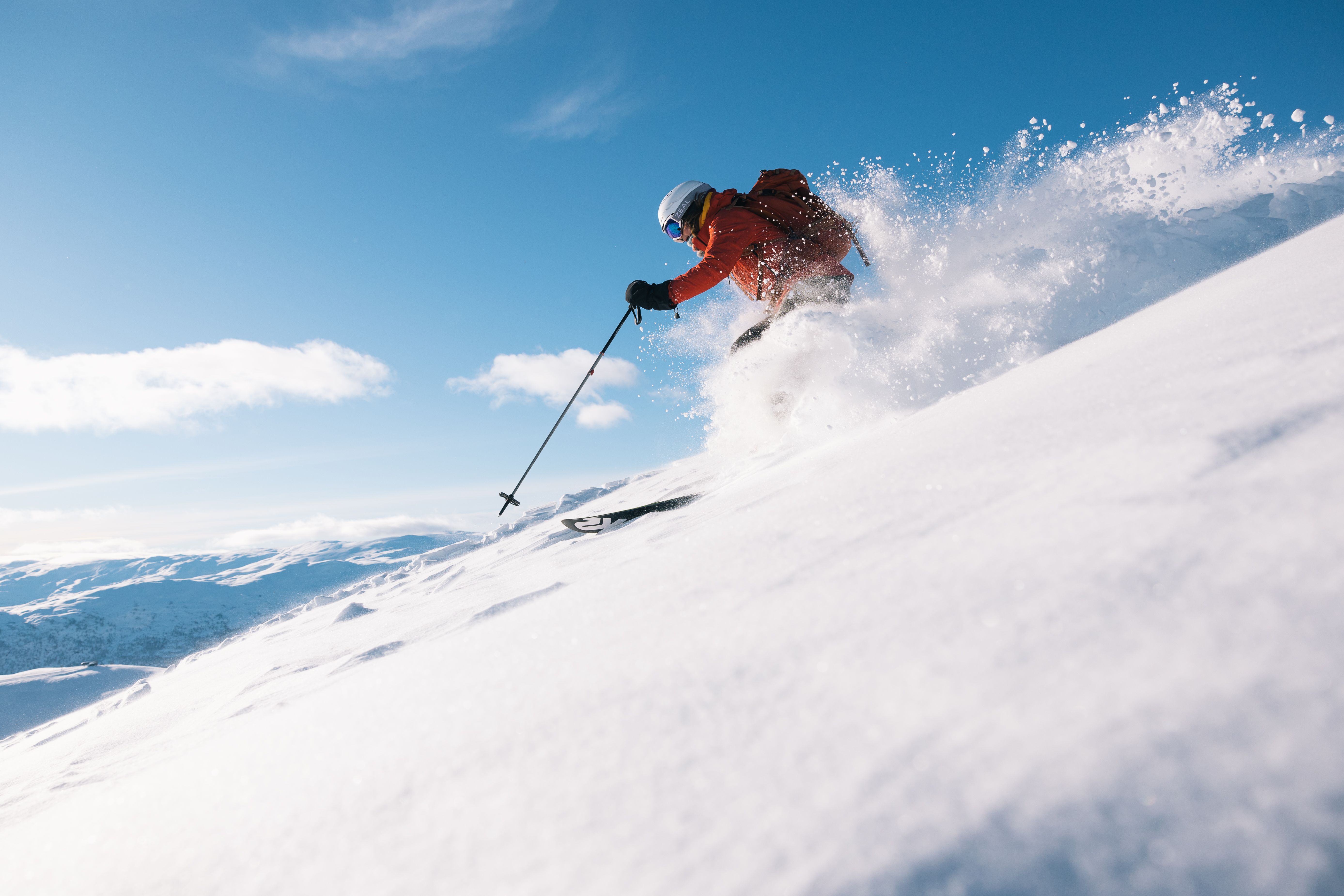 Skier in powder with blue skies in the background