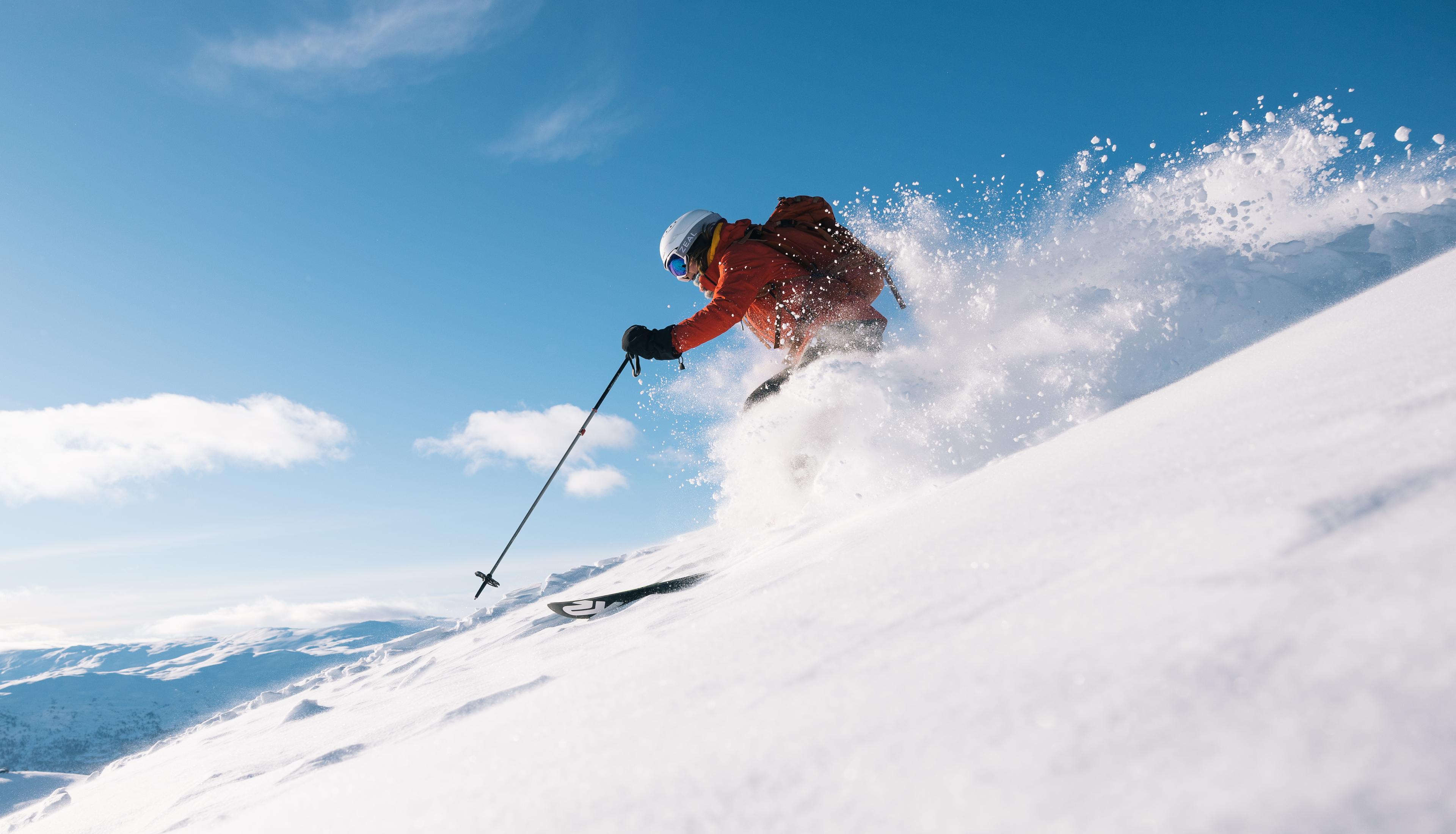 Skier in powder with blue skies in the background