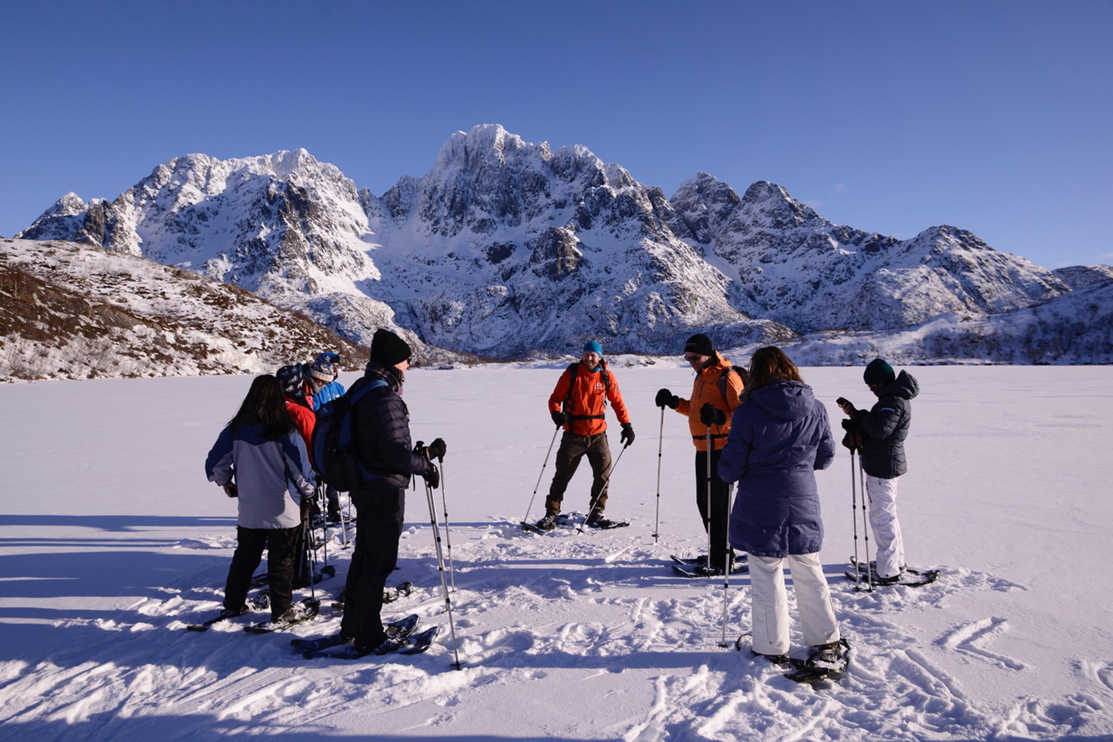 Under clear blue skies, tourists take in the breathtaking snowy mountain views