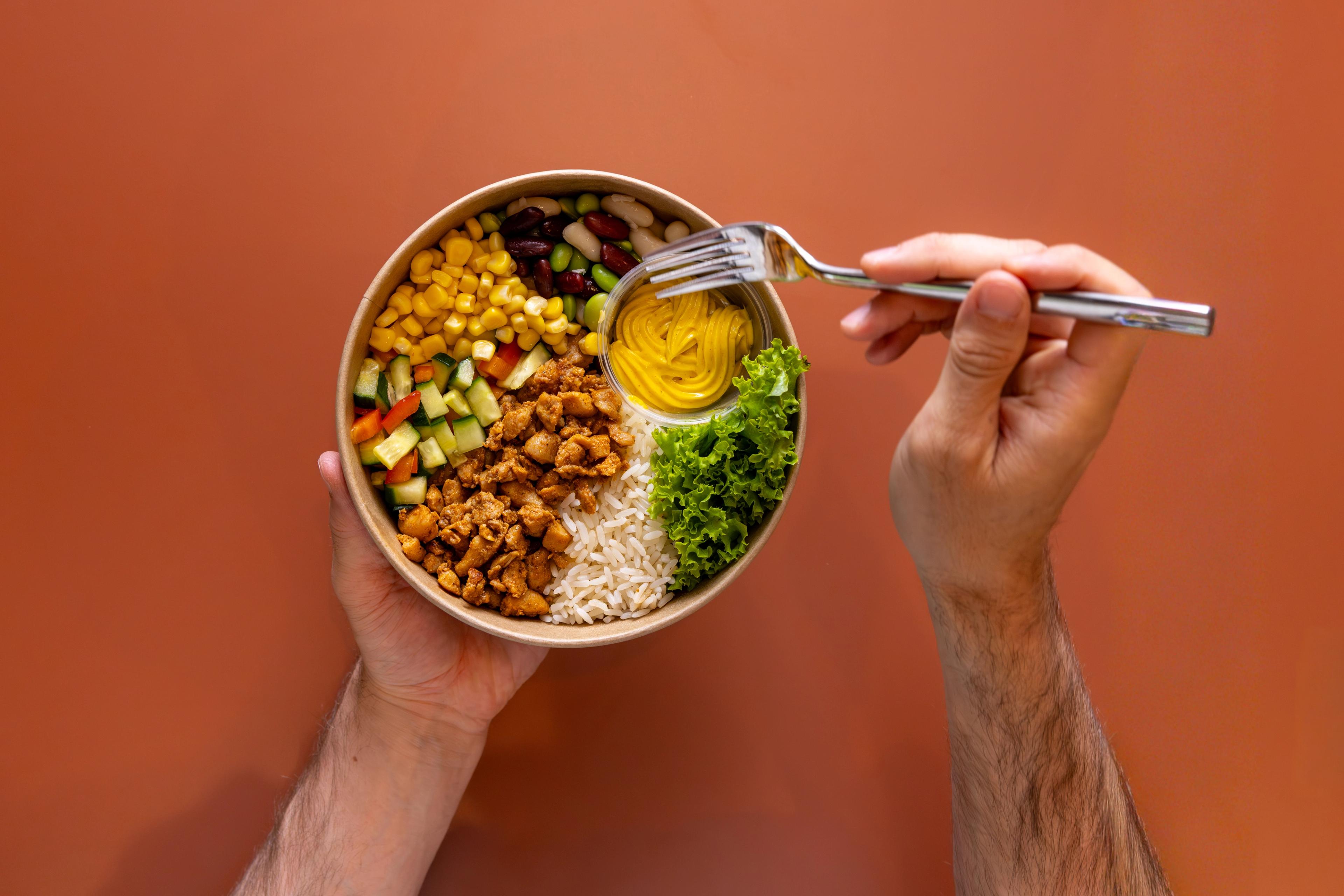 Hände, die eine Bowl halten und davon gleich essen werden.