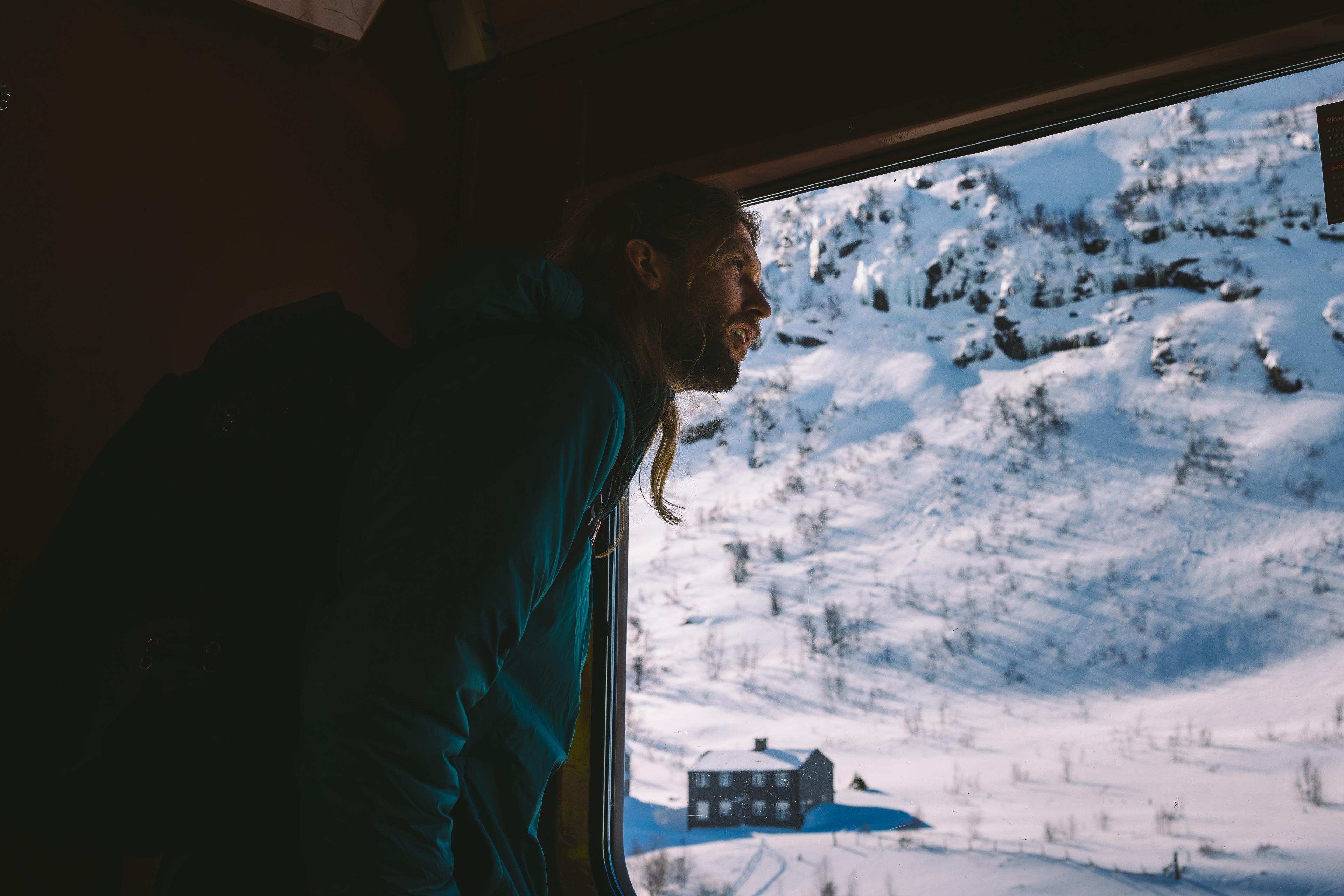  A man looks out of the train window and admires the view.