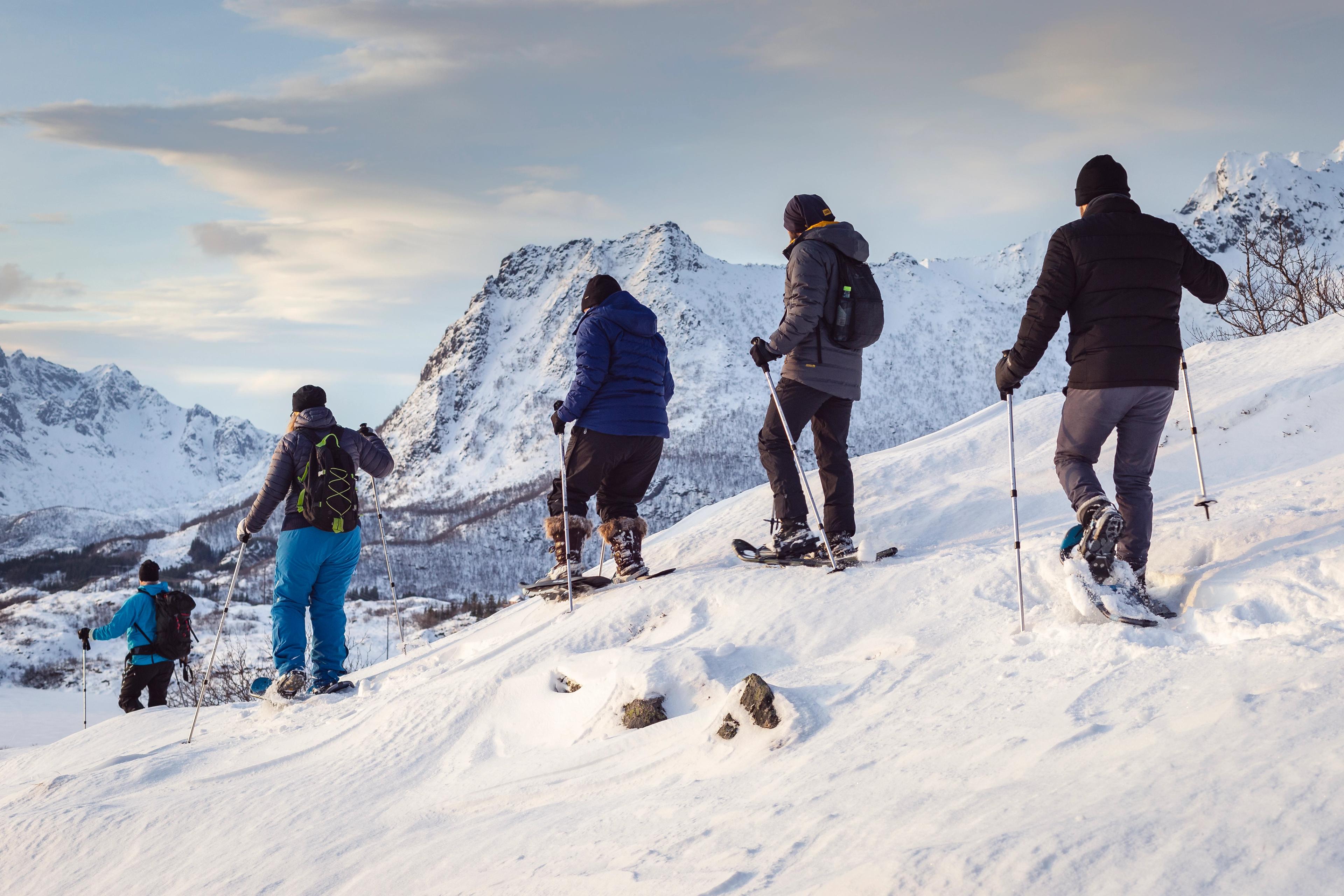 Personas en una caminata con raquetas de nieve en las montañas