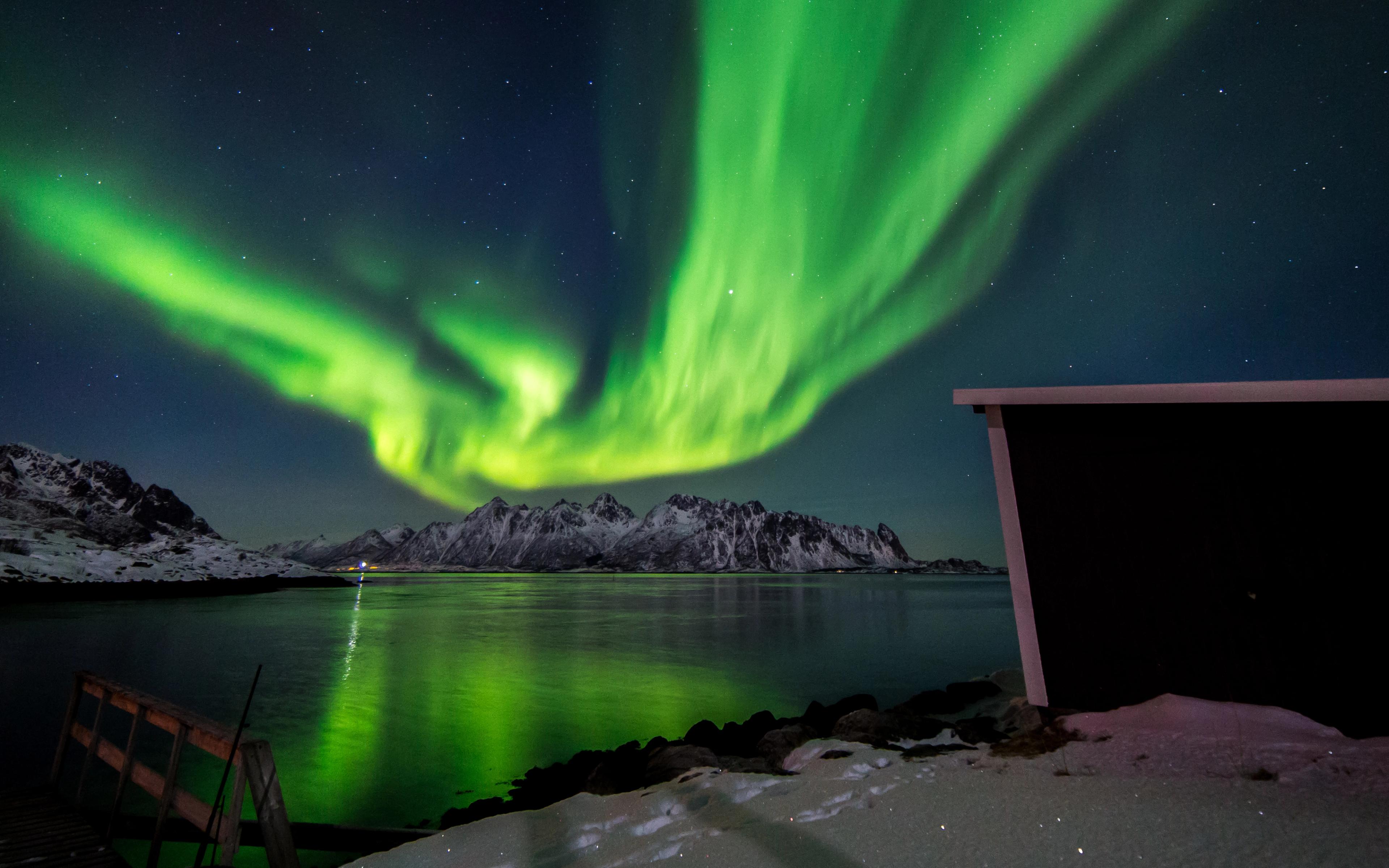 Starke Nordlichter über einem schneebedeckten Berg
