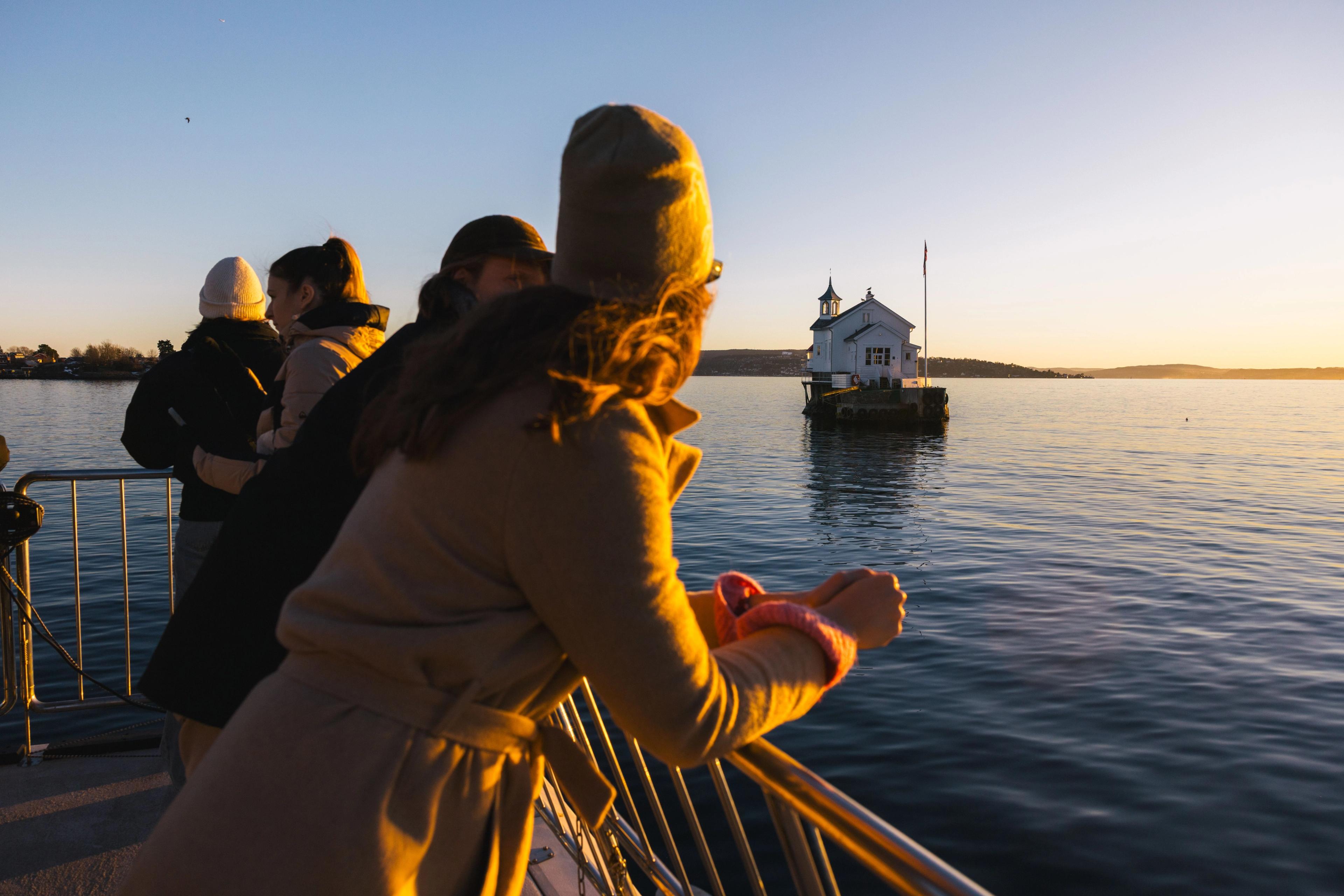 Tourists looking out over the fjord in sunset