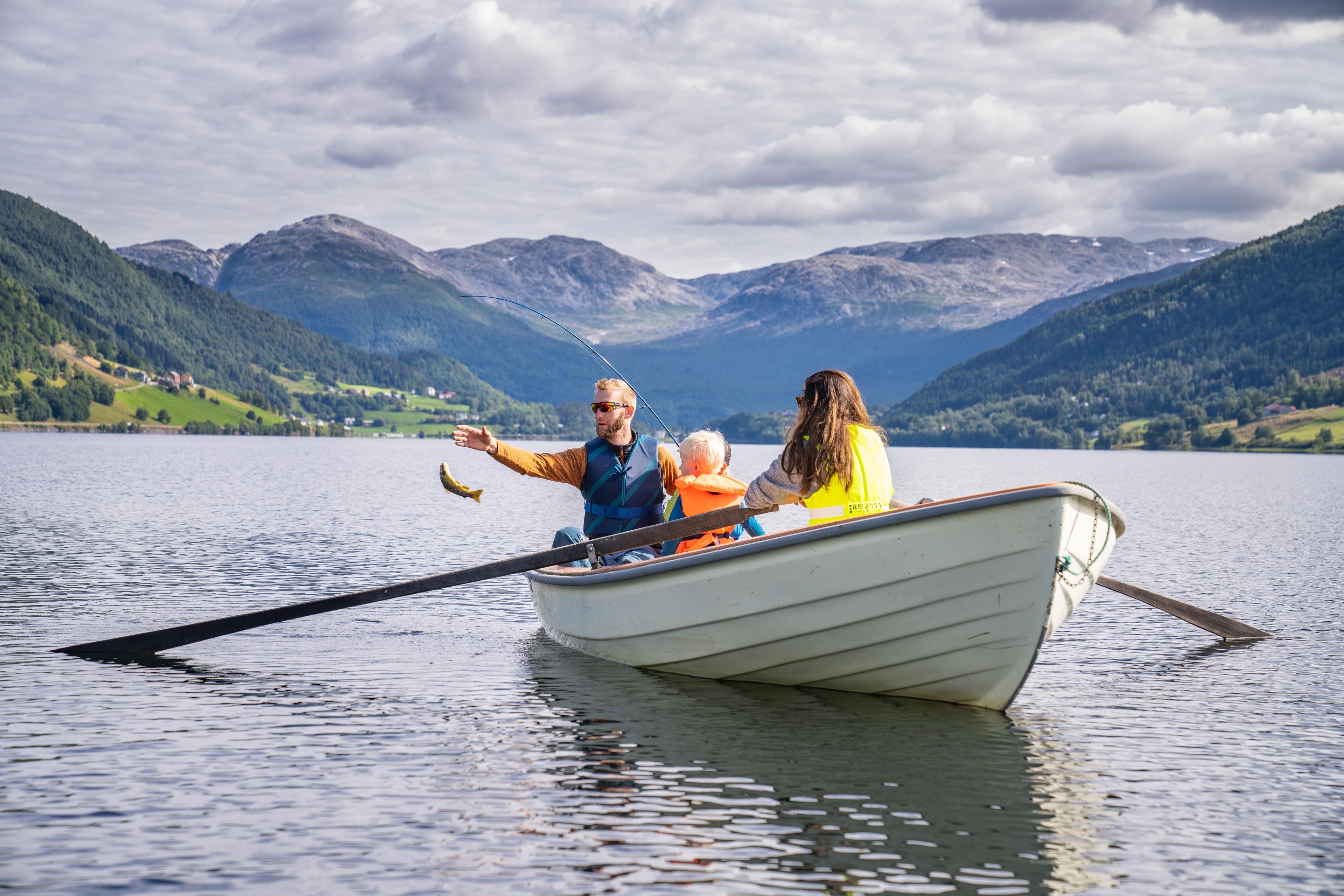 Familie i robåt har fått en fisk på kroken.