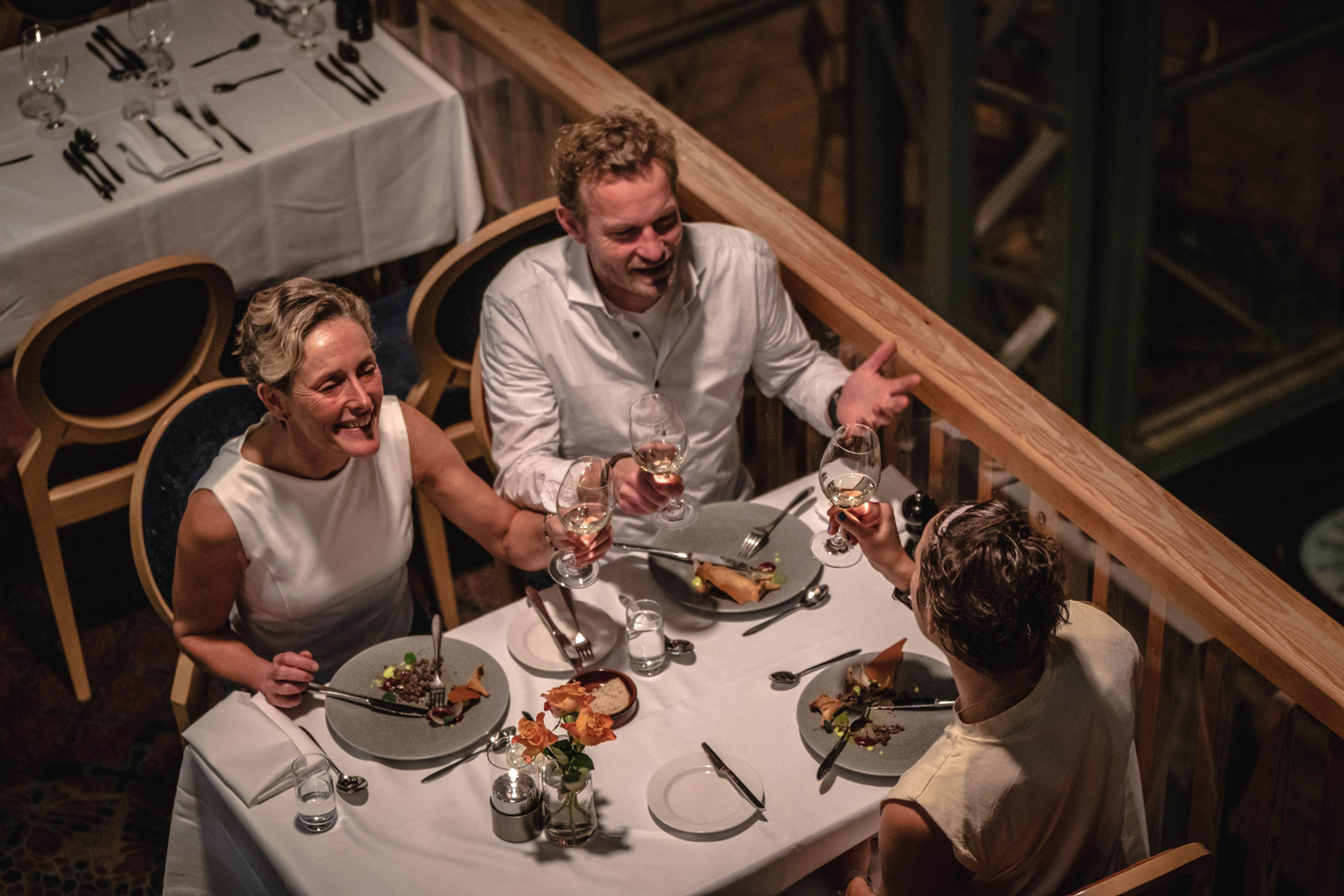 Three people around the dinner table. Laughing.