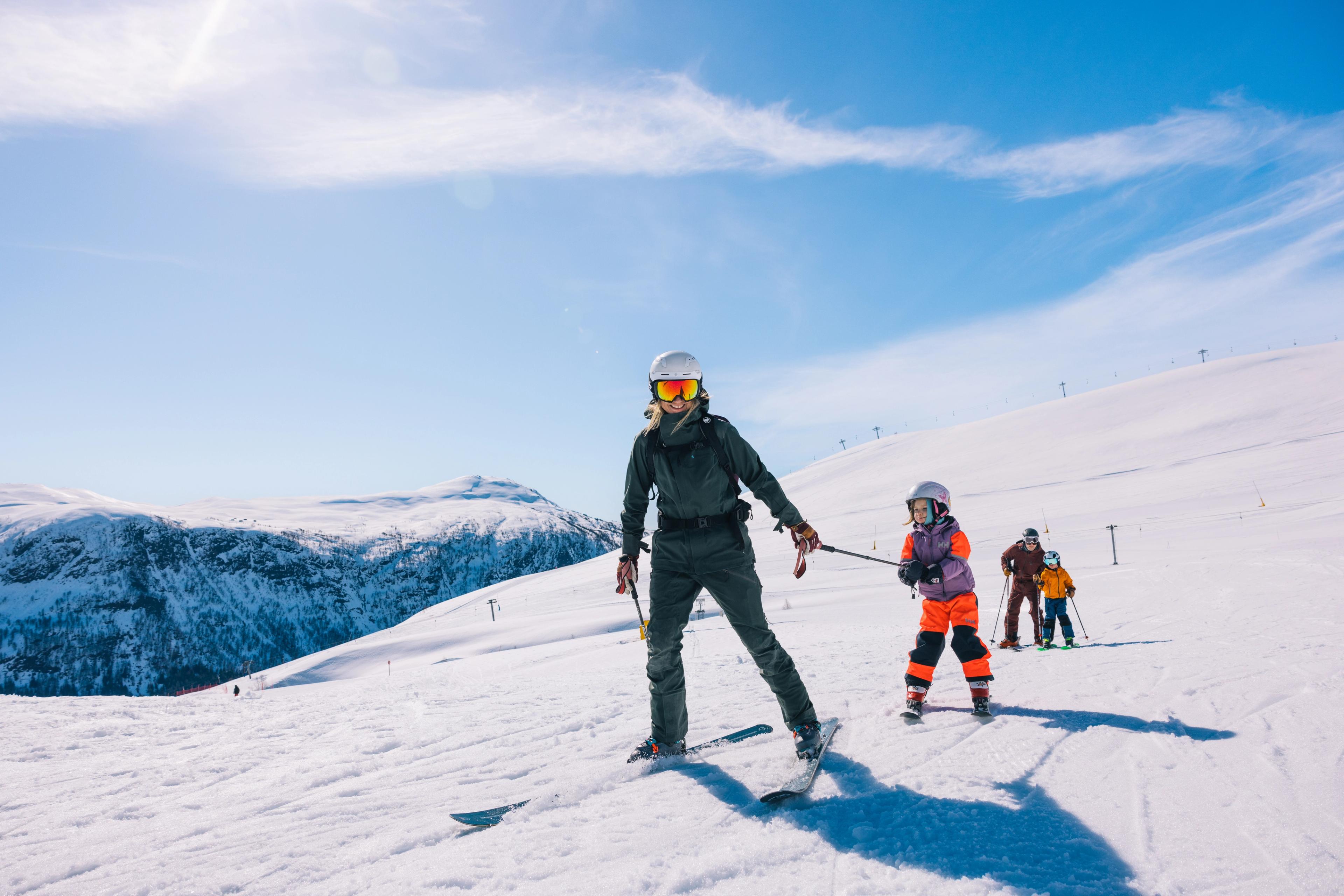 Familie på ski i Myrkdalen. Mor drar datter etter staven, far og sønn kommer bak. 